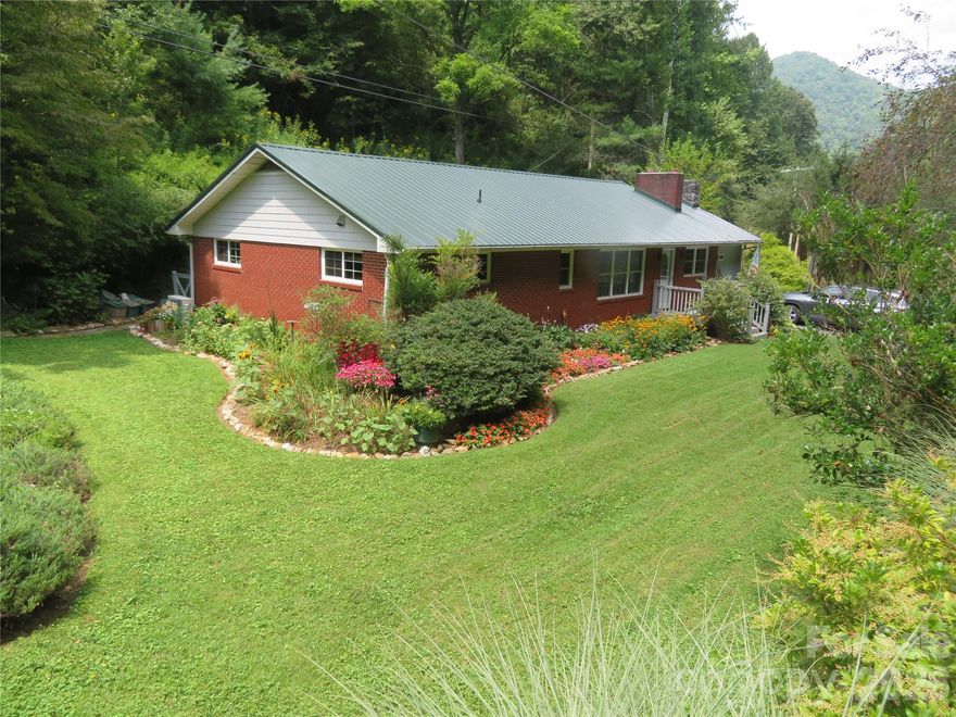 This amazing property is back on the market after renovation. Escape to a lifestyle of quiet beauty in this 4-bedroom, 2-bath brick split floor plan sanctuary. Nestled on 10 pristine acres in Yancey County, this property is a just a 20 minute drive from Burnsville. Both Asheville and Johnson City, TN are only an hour away. The well-maintained brick home features large bedrooms, spacious baths, two gas log fire places, a full basement and a newly renovated primary en-suite. The beautiful kitchen is designed for efficiency, with deep cabinetry, ample counter space, and two dedicated closet pantries. French doors lead out onto the patio. Two, well equipped outbuildings offer possibilities for workshops, office space, hobbies or storage. Both home and outbuildings have access to high speed internet, using fiber optics. The property has it’s own spring, well and a 500 gal. propane tank. Recent improvements include new roof, heating/air conditioning, water heater and a fenced in area for pets. The seller-paid 2/1 rate buy down makes your first two years of home ownership more affordable. It is time to claim your piece of the mountains. Rarely does a home offer this much value, natural beauty and such a significant financial advantage. Don't wait—this unique blend of value and serenity won't last long!
