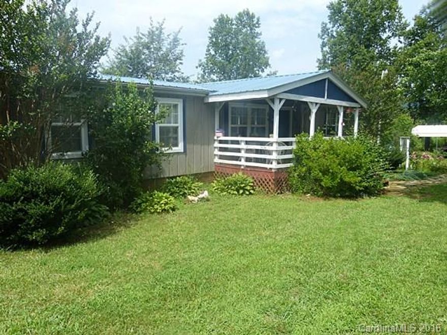 Nicely landscaped rural home that is a real garden spot. Manufactured home with three porches to enjoy tranquil surroundings. Mountain views from the back porch. Home is in immaculate condition. Open concept with kitchen between dining area and breakfast seating. Has a laundry room and a bonus room for storage.  Metal roof and wood siding. Two outbuildings, one with electric. Lots of flowers and other plantings. Home has a whole house transfer switch but the generator will not convey.