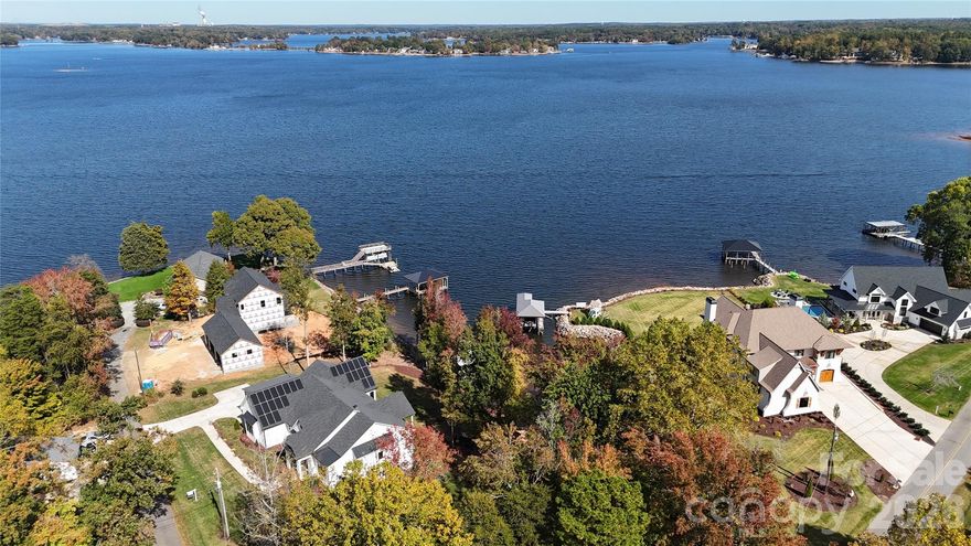 Discover luxury living at its finest with this breathtaking waterfront ranch home on 1.17 acres.  Nestled on a picturesque sandy beach with a private dock on Lake Norman, this property boasts stunning long-range views. The spacious open floor plan features a master suite on the main level, alongside two additional bedrooms, ensuring comfort and privacy. Entertain with ease in the gourmet kitchen with a walk-in pantry, flowing seamlessly into the dining and living areas. The finished basement is an entertainer's dream, complete with a second kitchen/bar, theater room, and additional primary bedroom with an en-suite bath. Enjoy year-round outdoor living with porch heaters and room for a pool.  Additional highlights include a bonus room over the garage, EV chargers, and smart home features. No HOA restrictions allowing the property to produce income through short term rental /vacation rentals with proven history, making it a smart investment. SELLER FINANCING AVAILABLE!!!