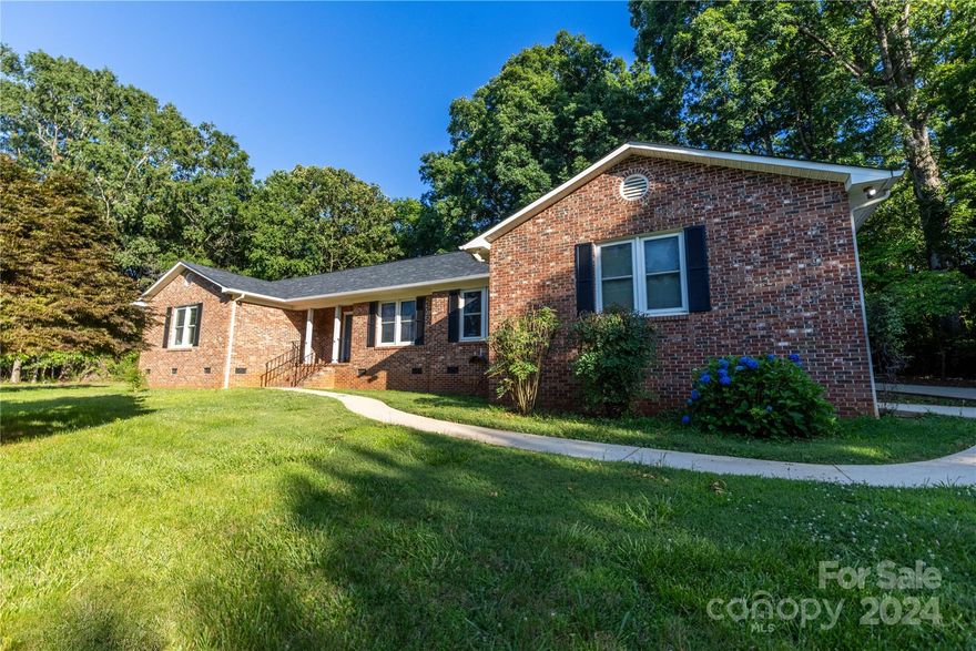 SOLID, totally rehabbed RANCH property in excellent condition. All-brick exterior affirms the sense of strength and good original construction standards of this home. Nothing left untouched in refurbishing this beautiful property. Conveniently located CLOSE TO I-77 and major roads, businesses, shopping, entertainment - sidewalks to nearby areas - with quiet ambiance. LVP throughout. Quartz kitchen counters, all new cabinets with soft close doors/drawers in this exquisite kitchen. All new stainless appliances, disposal; NEW fridge conveys. New ceiling fans in LR, bedrooms; new lighting. 3 baths, new vanities, fixtures. Ensuite primary bedroom. Well-positioned laundry room off garage and back door doubles as a mud room with full bath (shower) available before entering main living area. NEW ROOF. Wide garage, fits 2 cars, extra storage room. HUGE attic storage. Outbuilding with electricity. Water well has great capacity. Hydrant on property line; public water accessible. Beautiful trees.