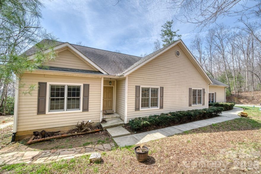 Excellent Value, Privacy, Views, and the Best of South Asheville — all on 2 acres.

Do not miss this beautifully maintained mountain home strikes the balance that buyers search years to find: a serene, wooded retreat with winter mountain views, yet just minutes from the shopping, dining, and conveniences of South Asheville.

Inside, vaulted ceilings and an open floor plan create an expansive, airy feel anchored by a wood-burning fireplace and a seamless flow between the living, dining, and kitchen spaces. The kitchen's generous breakfast bar makes it equally suited for quiet mornings and easy entertaining.

The primary suite is a true retreat — featuring a garden tub, walk-in closet, and private access to the expansive back deck, where mountain views and total quiet await. Two additional bedrooms and a second full bath complete the main level.

The finished basement adds remarkable flexibility and income potential— a second living area, home gym, guest suite, or all three. Currently it's rented (tenant leaves in April) for $1800 mo. 

Step outside and the property truly comes alive: a fire pit, a natural stream, apple trees, and a back deck made for long evenings. The 3-car attached garage, RV electrical hookup, and ample storage make this as practical as it is beautiful.

This is mountain living without the tradeoffs. See it today!
