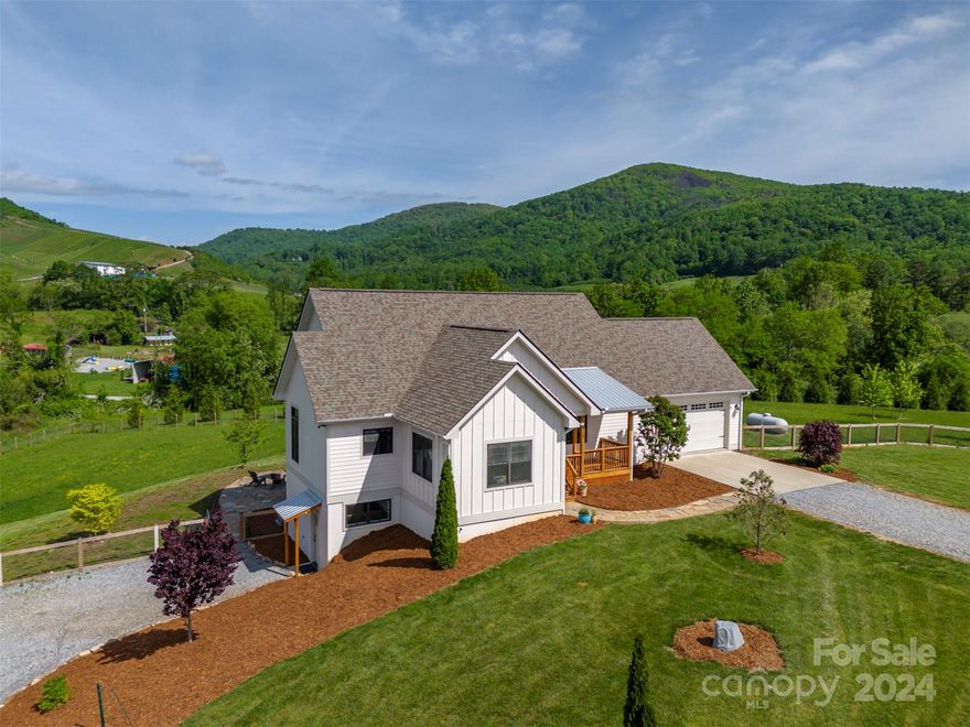 This custom modern farmhouse is situated on 2.2 +/- gentle, useable acres and boasts superior craftsmanship and thoughtful finishes floor to ceiling. The perfect combination of modern convenience and rustic style blends seamlessly into the mountain surroundings. From the Chicago brick foyer you'll be beckoned to the wall of windows to breathe in the stunning view of the mountains and nearby vineyard/winery. Welcoming great room with soaring pine ceilings, white oak floors, and gas fireplace. Brick accents flow into the kitchen alongside quality alder cabinetry, farmhouse sink, granite tops, and over and under cabinet lighting. Covered porch on the front and large covered deck on the rear along with a flagstone patio for outdoor enjoyment. Lower level features a full guest suite with its own driveway, private entrance, second primary suite, full well appointed kitchen and living room. Too many features to list both seen and unseen.