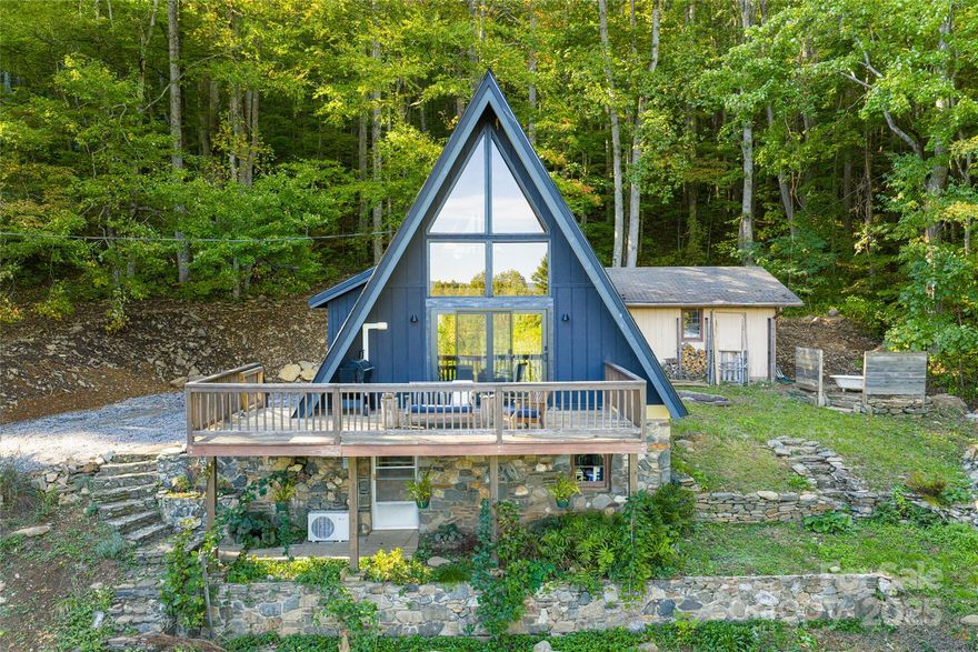 Situated at the end of a quiet road in the heart of the Celo Community, this extraordinary 37-acre legacy property is bordered on two sides by the Pisgah National Forest and North Carolina Game Lands, offering an unparalleled sense of privacy, serenity, and natural beauty at the foot of the Black Mountains.

The land encompasses pristine hardwood cove forest—one of North Carolina’s most biodiverse ecosystems where nearly all of the state’s medicinal plants naturally thrive. Combined with open fields, garden space, forested mountainsides, natural springs, and distant mountain views, this property offers a rare blend of ecological significance and versatility for those seeking a mountain sanctuary.

The updated A-frame home balances rustic charm with modern comfort, featuring an expansive glass wall, open-concept living, and panoramic mountain views. Interior updates include hardwood floors, an updated bath, and a modern kitchen.  It is the perfect home to live in while you build your dream home and then it can become an ideal guest house or Airbnb. 

Complementing the main residence are several versatile outbuildings—a two-car detached garage, a barn ideal for storage or restoration, an unheated studio space perfect for creative pursuits, an open-air pavilion, and a tractor shed. Trails meander through untouched woodlands, and with direct access to Pisgah National Forest, this property ideal for hiking, foraging, hunting, and wildlife observation.

Whether envisioned as a private mountain retreat, working homestead, hunting lodge or multi-home family compound, the property offers multiple homesites with expansion potential. Its garden spaces, established infrastructure, and protected surroundings create a true legacy opportunity for those drawn to a lifestyle defined by connection with nature.

Located a short distance to Burnsville, the Blue Ridge Parkway, Carolina Hemlocks, and Mount Mitchell State Park, this is more than a property—it’s a way of life. A rare chance to own a legacy mountain tract in one of the most sought-after natural settings in Western North Carolina.