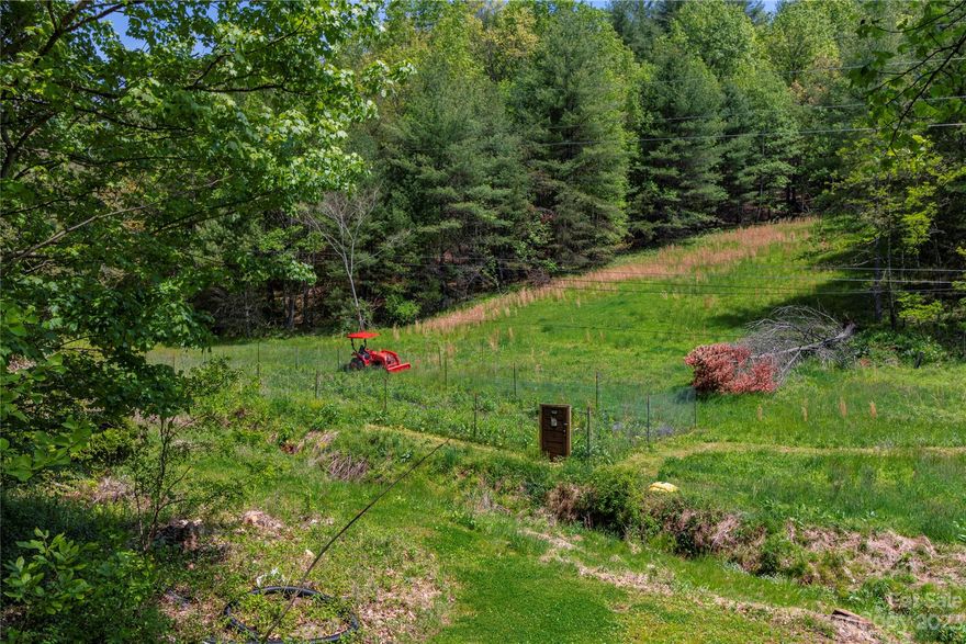 Well and septic installed, and RV site ready to use! NO RESTRICTIONS or HOA. Well producing 10 gallon a minute when drilled in May 2022.  Property has wooded area and open field to garden.  Plenty of wildlife for hunting, plus just minutes to Toe River for fishing and tubing.  Included is storage building that has full size range/oven, Full size refrigerator, Deep Freezer, and stacked washer and dryer. Bring your RV and you will be ready to camp!  Seller willing to sell RV and tractor on property.  Don’t let this one get away!   Would make perfect vacation or year-round home. On the westside on Burnsville to give you access to town or travel into Weaverville and Asheville.