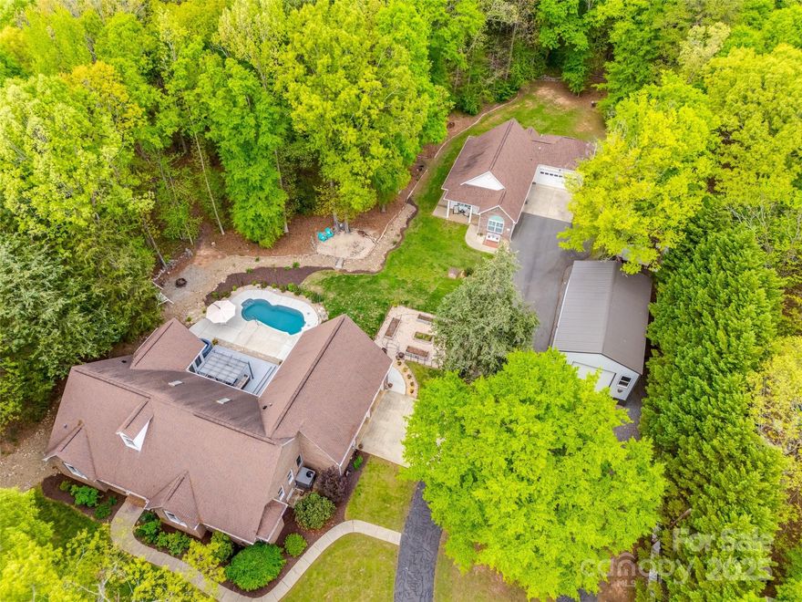 Live the ultimate lifestyle on 2.95 private acres with TWO pristine HOMES, a dream workshop, and resort-style outdoor living. Unwind in a gorgeous all-brick ranch with a charming porch, rich hardwood floors, vaulted ceilings, and an open-concept kitchen perfect for gatherings. Flex room above the oversized 2-car garage, screened sunroom, and spacious patio lead to a saltwater pool and cozy beach area ideal for lounging. Savor fresh produce from your vibrant fenced vegetable garden. The second home blends function and comfort with brick/hardboard siding, 2-car garage, wide accessible doorways, vaulted ceilings, open kitchen, and bright living/dining areas. Relax outdoors on the peaceful patio. The fully insulated workshop offers a mini split unit, large loft, car lift-ready floor, front roll-up and rear garage doors. Enjoy morning walks on wooded trails or sharpen your aim at the private shooting range. Whether hosting friends, soaking up the sun, or exploring nature—you’re home.