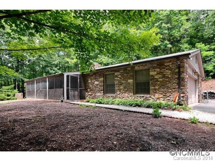Handsome stone-clad ranch in a beautiful private setting in Brush Creek. Lovely hardwood floors and plenty of windows for mountain breezes. Bonus sunroom not included in square footage. Also half bath in garage not included in bathroom count. Period charm awaits your personal touches to update. More photos to come! Property conveys by special warranty deed.