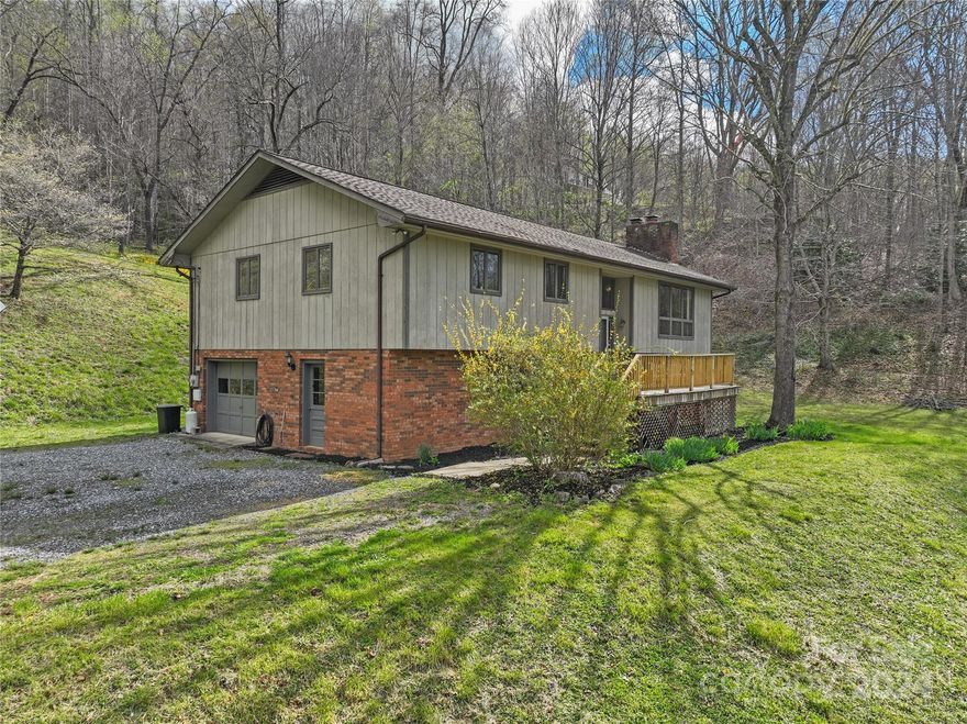 This spacious home has so much to offer in a private setting. A open entry leads up into a spacious living room with a wide hall leading to the bedrooms.  The lower level offers a second kitchen area, a large open area that could be used in a variety of ways, and another room that could be used for a number of uses such as an office or craft room.  There is also a garage with a walk out door on the lower level. Around the home there is a spacious yard and a view out of the front of the home.  Off the rear of the home there is a deck on the upper level and patio on the lower level.  The location is convenient to Sylva, Cullowhee, and WCU.