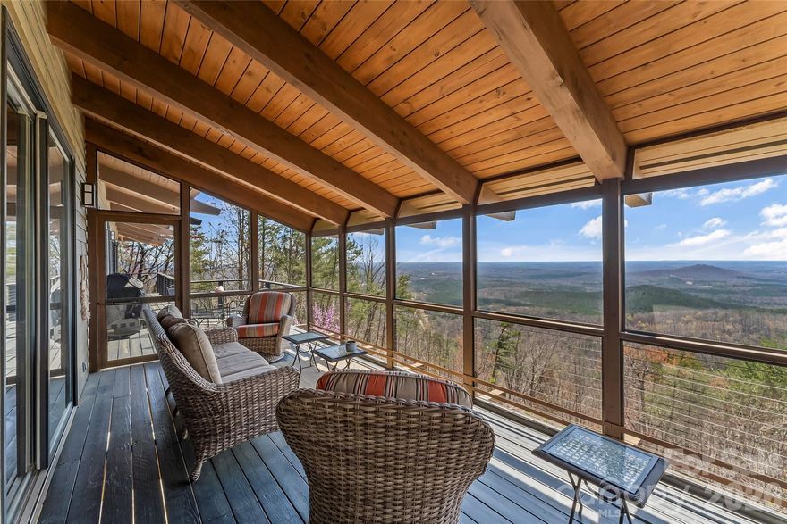 Extraordinary Haiku-inspired mountain retreat where Japanese design principles meet the natural beauty of Western North Carolina. This 3BD/3BA Haiku House captures sweeping long-range mountain views, creating a serene setting that feels both luxurious and deeply connected to nature. Thoughtfully designed with balance and tranquility in mind, the open floor plan features warm wood flooring, exposed beams, and expansive windows that frame the dramatic views. Natural light pours into the living spaces, enhancing the home’s peaceful atmosphere. The living room centers around a cozy wood-burning fireplace, while a bright sunroom offers the perfect place for quiet reflection, reading, or morning coffee while overlooking an endless sea of stunning mountainous landscape. The kitchen blends style and functionality with high-end stainless steel appliances, a central island, and generous cabinetry. The primary suite is a private sanctuary with direct deck access, a walk-in closet, and a spa-inspired ensuite bath featuring a dual vanity and a traditional Japanese soaking tub, reinforcing the home’s Zen-like design and focus on relaxation. The lower level is partially finished with 522 sq ft of non-contiguous heated bonus space that makes an ideal recreation room or additional living area. This includes a 3rd full bath, making it easy to transform this space into 2nd living quarters. Also on the lower level is another non-contiguous room (223 sq ft) currently used as a meditation room. You'll love the space and possibilities this sacred retreat holds! Outdoor living areas are perfectly positioned to capture the panoramic mountain vistas, inviting you to unwind and fully experience the peaceful surroundings. This distinctive property offers exceptional versatility as a primary residence, private mountain retreat, or income-producing investment. STRs allowed! Furnishings negotiable. Savor the tranquility of mountain living with convenient access to dining, shopping, and local attractions. This is a rare opportunity to own a one-of-a-kind mountain sanctuary inspired by the beauty and simplicity of a Haiku.