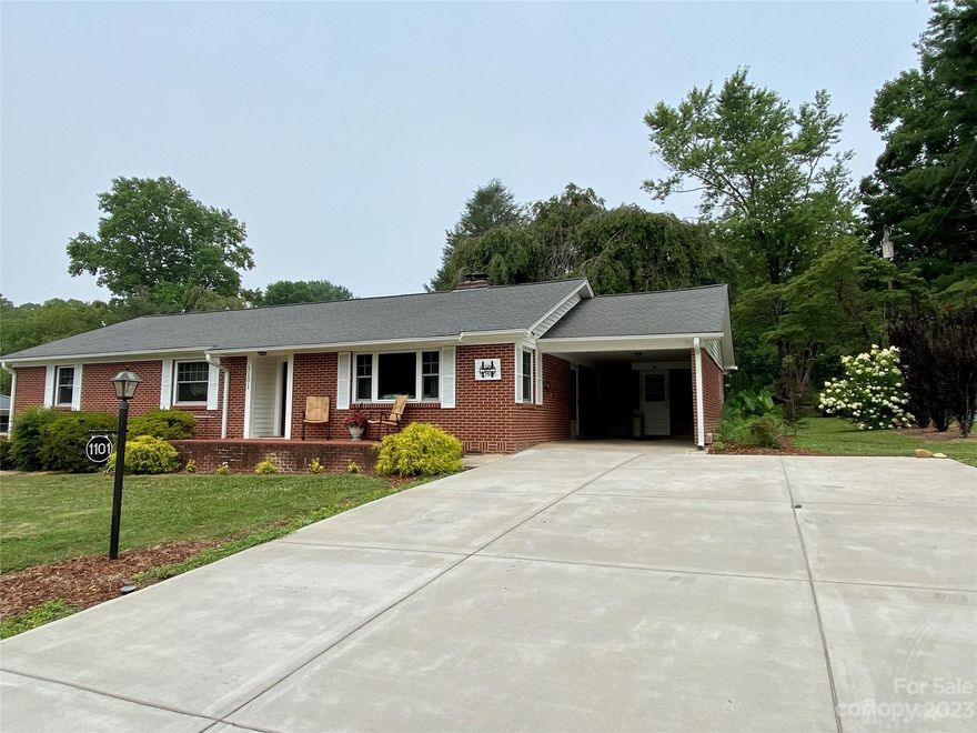 First time offered, one level brick home within minutes to downtown Hendersonville!  Features spacious rooms, original hardwood flooring, brick fireplace in living room, kitchen adjoins den.  Part unfinished walk-out basement offers great room for work-working, hobbies, storage, etc.  Two carports, utility room and storage building, covered rear patio w/fenced back yard.