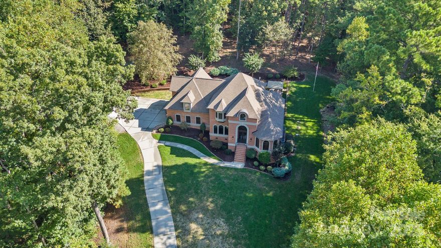 Welcome to a beautifully maintained full-brick home with seasonal views of Lake Norman, set on nearly 2 peaceful acres. From the moment you pull in, the long driveway, mature trees, and thoughtful landscaping create a sense of privacy and calm that makes this property feel special.
Inside, you’ll find quality details throughout—3-piece crown molding, wide baseboards, wood floors, built-ins, plantation shutters, and a warm wood-planked vaulted ceiling in the study. The main-level primary suite offers a comfortable retreat with a tray ceiling and a relaxing, spa-like bathroom.
The kitchen is both functional and inviting, featuring classic cherry cabinets newly refinished in white for a fresh, clean look. Granite counters, a stone backsplash, stainless steel appliances, soft-close drawers, and a Thermador gas cooktop make it a great space for cooking and gathering. The kitchen opens to the great room, where a gas fireplace adds a cozy touch.
Upstairs, three additional bedrooms provide plenty of room for family or guests. There’s also a spacious bonus room with a wet bar and a fully set-up theater room—perfect for quiet evenings in, movie nights, or celebrations.
Outside, the saltwater pool, large patios, and surrounding green space offer plenty of places to relax or entertain. The property borders 16 acres of greenway, giving you extra privacy and room to enjoy nature. Two walk-in storage areas add convenience for everyday living.
Located just minutes from schools, shopping, dining, lake access, Lake Effects Boat Club, and major routes like I-77 and Hwy 16, this home offers a quiet setting without being far from what you need.
If you’re looking for a home that’s well cared for, comfortable, and surrounded by natural beauty—this one is truly worth a visit.