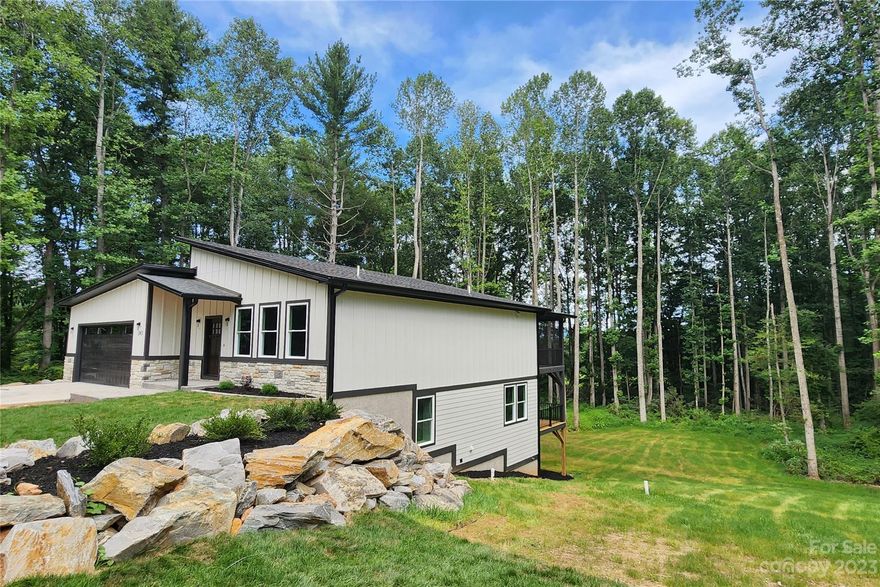 Contemporary New Construction, with a mountain view, close to shopping, dining, and Mills River Park. With contemporary angular elegance, this 3-bedroom, 2.5-bathroom is found in the Echo Valley Acres community,  a great location. The interior offers a fantastic floor plan, you'll find an open layout, stylish lighting, neutral decor, and vaulted ceilings. The luxurious kitchen features contemporary trends and premium appliances. The tranquil main-floor primary bedroom includes a spa-like ensuite bathroom and walk-in closet with built-ins. The other two bedrooms, office, and family room are located on the lower level for privacy. The attached two-car garage is conveniently located on the main level. The exterior includes a two-story, covered deck, front porch, and generous backyard.  An easy commute to Asheville means more time to enjoy the spectacular mountain views. It's a great idea to make a competitive offer on this one.