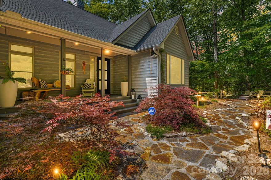 Boasting spectacular long-range, year-round mountain views from the dual covered decks, this Modern Mountain masterpiece offers the pinnacle of Blue Ridge living on 1.66 private acres. Sold fully furnished with high-end furniture, lighting, and artwork, this residence is a sophisticated, turn-key sanctuary—perfect as a primary residence, premium second home, or multigenerational living. The main level is defined by a breathtaking open-plan living room featuring soaring cathedral ceilings and a majestic floor-to-ceiling stone fireplace that serves as the home's primary focal point. For the culinary enthusiast, the gourmet kitchen boasts custom cabinetry and premium high-end appliances that flow seamlessly into the formal dining area. Uniquely designed for flexibility, the lower level features a separate entrance and second living quarters, including a massive recreation room and a second primary suite. The thoughtful layout also includes a dedicated home office, fully finished garage, and an elevator for effortless access across all levels. Outdoor living is equally impressive, as the expansive decks provide the perfect vantage point in any season. The professionally landscaped grounds further enhance the retreat feel with a custom stone sofa, a welcoming front porch, and a dedicated firepit area designed for crisp Carolina evenings. While providing a profound sense of seclusion, this home remains exceptionally convenient—located less than 20 minutes from the vibrant culture of Downtown Asheville and within 15 minutes of the premier shopping in South Asheville and the Asheville Regional Airport. Complete with a whole-house generator for uninterrupted peace of mind, this property represents a rare opportunity to own a fully realized luxury lifestyle in one of the region's most sought-after locations.