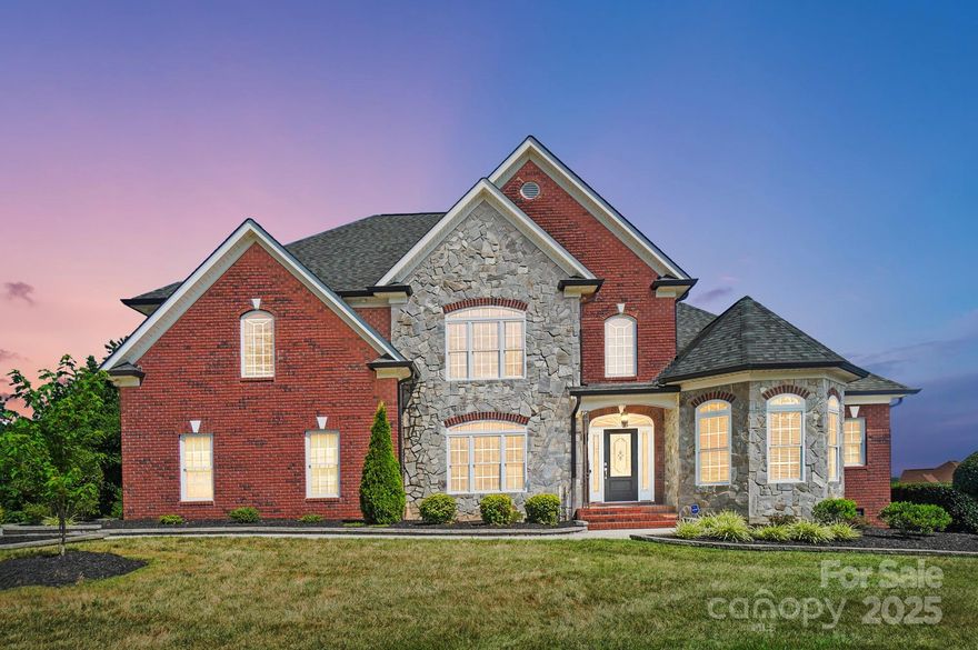 GET A BELOW MARKET INTEREST RATE FOR THE FIRST YEAR! All-brick home in a well-established community w/custom homes and top-notch amenities including pool, clubhouse, tennis & trails! Gorgeous curb appeal with 3-car garage and lush landscaping. Step inside to a dramatic 2-story foyer, through gleaming wood flooring and into an inviting open layout with a coffered ceiling and gas log fireplace. The chef’s kitchen features an island plus counter space all around, rich custom cabinetry, breakfast bar and sunlit morning room plus a butler’s pantry with wine fridge, perfect for entertaining. The main-level primary suite is a peaceful retreat w/spa-like bath, oversized shower, garden tub and huge walk-in closet. Each of the 4 bedrooms has its own ensuite bath, offering comfort and privacy for all. Large bonus room, private office, well-equipped laundry, and walk-in attic add thoughtful functionality. The extra-large backyard backs to community commons, creating a quiet, private outdoor space!