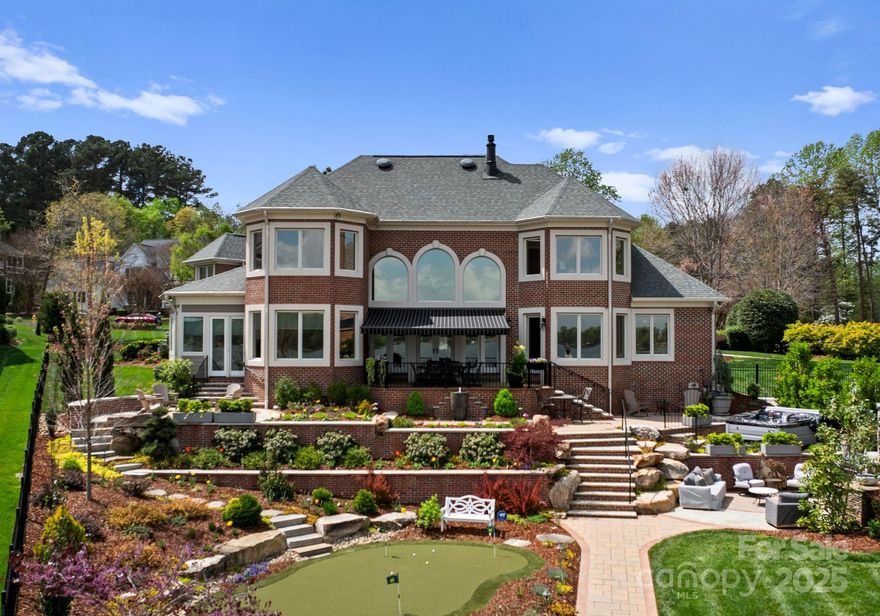 Located on a quiet cul-de-sac in the Sailview Community, this remodeled home offers stunning views of Lake Norman's main channel from almost every room. Inside, you'll find custom cabinetry and shelving in the gourmet kitchen, bar, fireplace surround, and owner's bath/closet. The home boasts top-of-the-line appliances, heated Travertine flooring, a sunroom addition, and Control4 Smart Home Automation. These are just some of the many recent updates that make this home special. Outside, discover a luxurious backyard paradise with newly constructed retaining walls, a hot tub terrace, a four-hole putting green, fire features, and a remote patio awning. One of the many highlights is a private white sand beach overlooking beautiful Lake Norman. As part of the Sailview Community, you'll also have access to a lap pool, clubhouse, sand volleyball court, and pickleball/tennis courts.
**NEW ROOF - construction completed on July 18th**