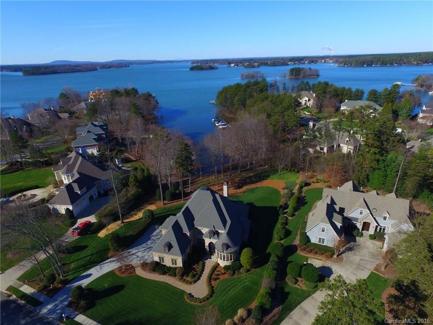 Majestic stucco LKN wf estate w/endless waterviews, designed for luxury living & entertaining boasts high craftsmanship & quality! Be drawn in from the foyer to the GR detail overlooking LKN or enjoy the nat light from the curved walls of the study. The stunning chef's kit w/comm appliances & built-in's are ready for gourmet prep w/a lg eat in kit or serve dinner in the elegant DR. Outdoor entertain from the covered patio & fab courtyard w/impressive stonework. Deeded boat slip down the street.