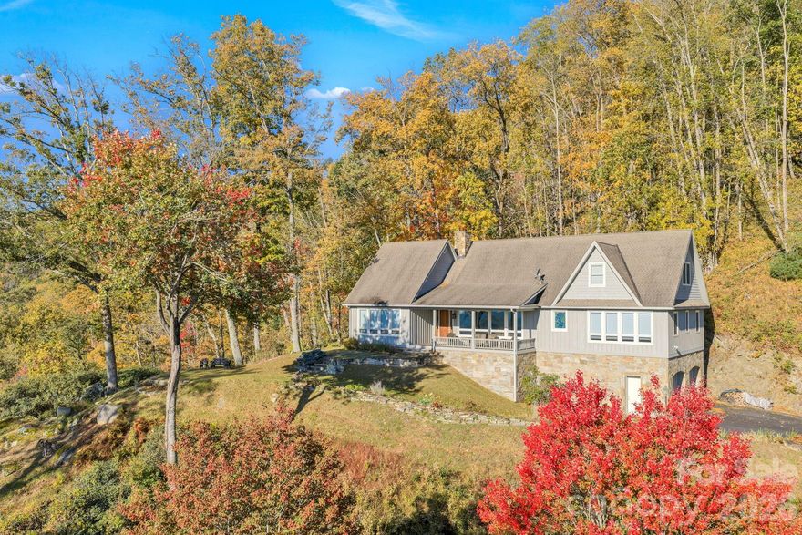 Set just below Thunder Hill Overlook along the Blue Ridge Parkway, this mountain estate offers a rare combination of privacy, acreage and long-range layered views. While the property carries a Lenoir address, it is located within the Blowing Rock school district, including Blowing Rock Elementary and Watauga High School, and is serviced by the Blowing Rock Fire District.
Positioned on approximately 27 acres, the three-bedroom residence includes three en suite baths and an open-concept floor plan designed for both daily living and entertaining. Interior finishes reflect a focus on natural materials and craftsmanship, including oak hardwood flooring throughout the main living areas and travertine tile in the kitchen and baths. Ceiling heights reach 10 feet, complemented by 8-foot doors, enhancing natural light and scale throughout the home.
Each bedroom suite offers its own distinct millwork with custom wainscoting in cherry, wormy maple, and sinker cypress, creating a warm, refined mountain aesthetic. The kitchen is appointed with granite countertops, hickory cabinetry, and a dual-fuel range, seamlessly blending functionality with timeless design. A spacious upper-level bonus room provides flexibility for additional living, recreation, or workspace. There is a two car heated basement garage.
Outdoor living is equally compelling, with a covered front porch perfectly positioned to take in the expansive views, as well as a dramatic rock outcrop accessed by stone steps—an ideal vantage point to experience the surrounding natural beauty.
Additional features include high-speed internet via Skyline/SkyBest and a pre-installed Ring security system. The property consists of two tracts, including one with potential for a future homesite. 
A truly distinctive offering where natural beauty, privacy, and craftsmanship converge, within one of the region’s most established mountain corridors.
An expired septic permit is on file for Tract 2, and a septic easement is in place. A portion of the land has been conveyed to the Blue Ridge Parkway, and the property is enrolled in a Forest Management Plan, which provide reduced property taxes and is subject to continuation to receive the tax benefits.
There is a 303 sq. ft. difference between the tax record and professional measurements likely due to the stairwell to the basement and a heated storage room in the basement.