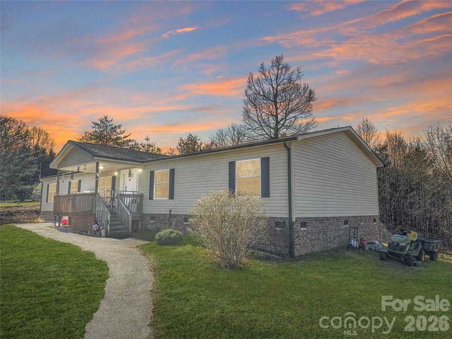 Welcome to your serene mountain retreat! Nestled on a peaceful +/- 1.24-acre double lot atop a gentle ridge, this 2004-built single-family home offers +/- 2,100 sq ft of thoughtfully designed living space with stunning views and modern accessibility features.  Enter onto the welcoming covered front porch — perfect for morning coffee while soaking in those breathtaking mountain vistas — and note the ADA-accessible elevator lift system for effortless entry. Inside, the heart of the home is the expansive open great room, seamlessly blending the living area, kitchen, and den for effortless entertaining and everyday comfort. The cozy den features a gas fireplace as a focal point. The kitchen is practical and inviting, complete with a center island (with sink and bar seating), built-in wall microwave and oven, dishwasher, refrigerator, and plenty of counter space for meal prep. The massive owner's suite is a true sanctuary: generous bedroom space plus a separate versatile room ideal for a home office, workout area, or dressing room. The en-suite bathroom boasts a walk-in shower alongside a luxurious freestanding walk-in tub with door — perfect for relaxing soaks with easy, safe access. On the opposite end of the home, you'll find two additional bedrooms, a full bathroom, and a flexible office or hobby room for guests, family, or creative pursuits. Out back, the rear deck opens directly from the great room, offering close-up views of the fenced backyard and surrounding woods, plus sweeping distant mountain panoramas — an ideal spot for outdoor dining or simply unwinding in nature. Additional highlights include a convenient storage building on the property, ample parking, and the home's elevated position for privacy and those incredible views. This single-level layout combines comfort, accessibility, and natural beauty — whether you're seeking a peaceful primary residence, a downsized dream home, or a mountain getaway. Don't miss this rare opportunity!