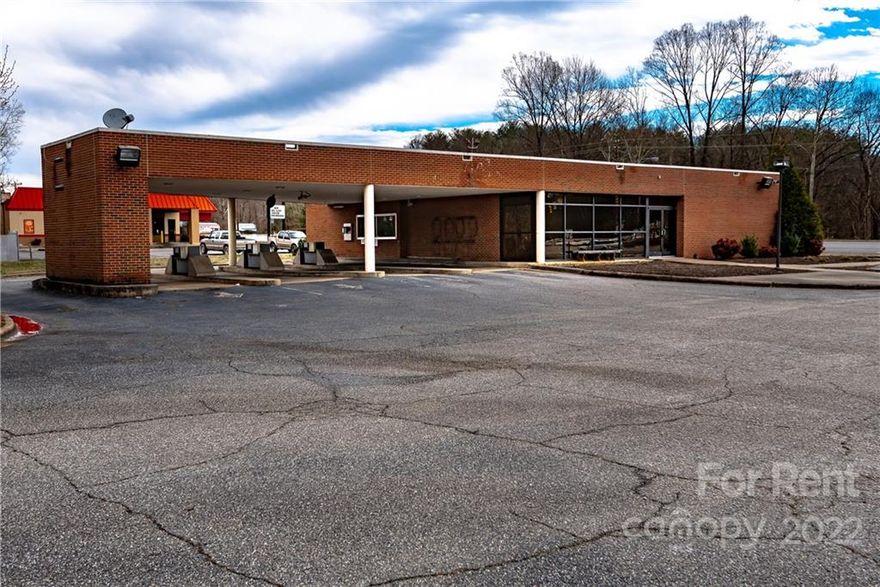 BUILDING FOR RENT This building is located on one of Lenoir's busiest main thoroughfares and is accessible from three different streets. Originally built for a bank, the building has 3,408 HSF with four drive through covered lanes.  Most recently used as a car dealership.  Has 33 marked parking spaces.  Lease is triple net with an initial base rent of $3,500 and a security deposit of $3,500. Minimum three year lease period. Qualified applicants can get a copy of a draft lease agreement from the listing agent.