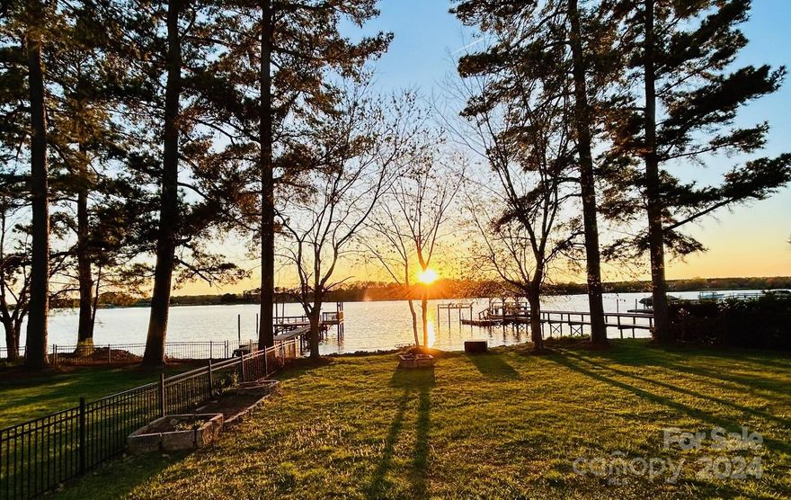 Exquisite Level Waterfront Property w/ Long Range Water Views of the Main Channel out the Back & Water Views out the Front, in MOORESVILLE w/ NO HOA! Located just outside The Point/Trump National Golf Course & the LKN Yacht Club just a short walk away. There are WATER VIEWS from just about every room. 3 bedroom 2.5 bath brick ranch home w/ open floor plan, bonus w/ big walk-in attic above the oversized 2 car garage. Off-site septic located across the street w/ 3 bedroom septic currently that could potentially be expanded to a 4 bed. Having the septic off-site provides less restraints to allow for renovation, adding onto the existing home, or building a NEW HOME w/ the option of a pool/bigger footprint home etc. The lot has 113' of beautiful Lake Norman Shoreline & a western exposure w/ Picturesque Sunsets. One can watch sail boat races from the front porch or sea planes landing nearby! Be at one with nature while watching the Osprey & Eagles in their LKN habitat. Home sold as is