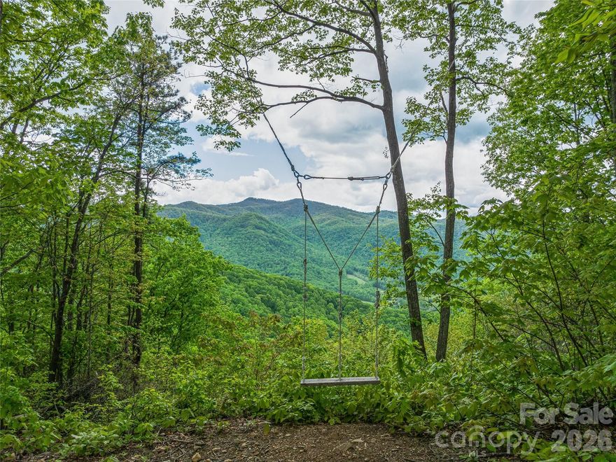 Pisgah Highlands offers a rare and exceptional +-124 acre opportunity in Buncombe County, perfectly positioned below the iconic summit of Mt Pisgah! Behind the private access gate, the topography features a long ridge line with plentiful build sites to choose from, each offering complete privacy and splendid mountain views into the national forest. Utilize miles of paved roads with underground electricity in place. The property features 3 fully furnished, off-grid glamping units - Treehouse, Ridge House, and Container House, plus a camping A Frame. The beautiful mountain environment features a mature hardwood forest, springs, creeks, wildlife, abundant wildflowers, plus a long border with Pisgah National Forest. Despite feeling a world apart, the convenient location is only minutes to both Asheville and the Blue Ridge Parkway. Ideal uses include subdivision, residential development, private estate(s), conservation, STRs, or a combination to achieve your vision. This land is special! Seller financing considered.