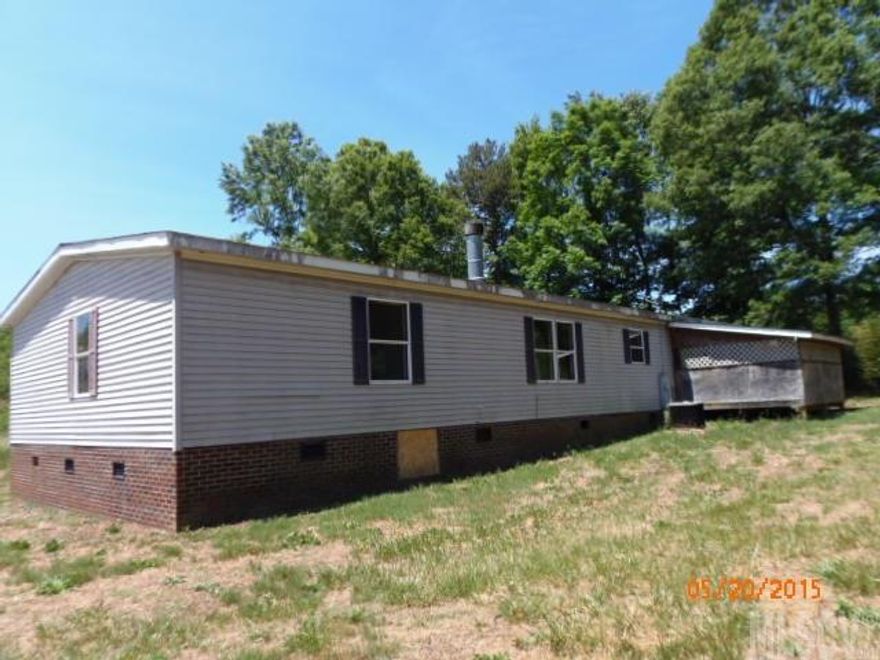 Country setting with easy access to I-40.  Large double-wide home with addition and enclosed porch.  Septic permit says four bedrooms and two bathrooms.  Buyer must verify all information-tax records is main source for information. Property will be sold as is-no repairs will be paid by seller.  Iredell County Permitting Dept shows permit #75935 in 1998 for addition to the home, but Dept is unable to verify inspections for the addition to different method of record keeping in 1998.