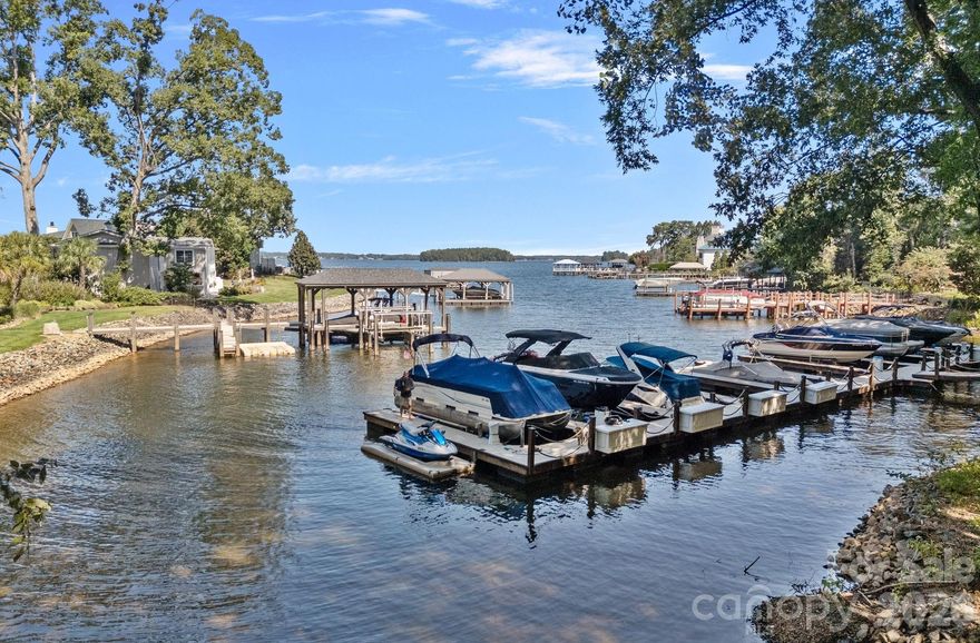 Proposed Custom Waterfront Estate in The Peninsula – Built by Augusta Homes! (Lot can also be purchased separately MLS #4297590) Nestled on one of the last remaining waterfront lots in the prestigious Peninsula neighborhood, this proposed custom masterpiece by renowned luxury builder Augusta Homes offers an unparalleled blend of elegance, comfort, and lakefront living.
The generous 1.21-acre WATERFRONT lot showcases long-range, main channel water views and boasts 263+/- feet of Lake Norman shoreline. While a dock is not permitted, there is limited lake access. This beautiful property offers an expansive open floorplan designed for both grand entertaining and relaxed living, featuring a chef’s kitchen with generous cabinetry and a spacious living area that flows seamlessly to the outdoors. The main-level primary suite is a private retreat with a spa-inspired bath including a garden tub, oversized glass shower, and a large walk-in closet, all opening to a covered lanai. Upstairs, you’ll find 3 ensuite bedrooms, a versatile bonus room, and a loft perfect for work or play. Outdoor living is elevated with long-range lake views, a covered terrace with fireplace, and a heated saltwater pool and spa. This rare opportunity combines Augusta Homes’ signature craftsmanship with the tranquility and prestige of The Peninsula—where luxury meets lake life. Just steps from The Peninsula Golf Club and Safe Harbor Peninsula Yacht Club, a private club for those who love boating. Don’t miss this rare opportunity to create your perfect home in one of Charlotte’s most exclusive communities. Conveniently located near groceries, restaurants, and shopping with easy freeway access just 18 miles to Charlotte and 20 miles to CLT Douglas International Airport.