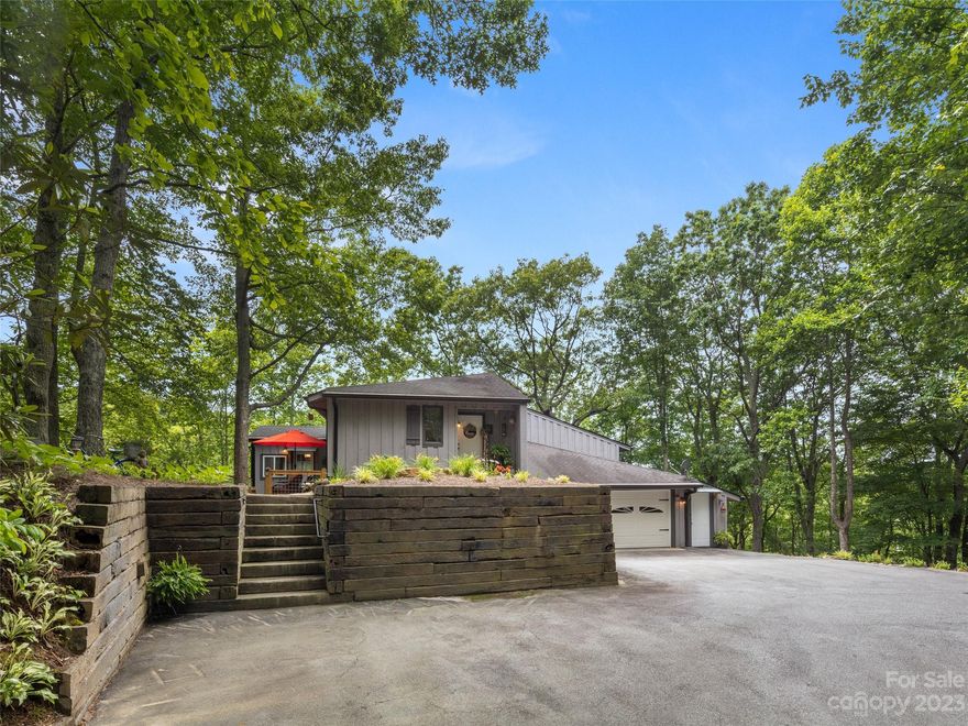 Escape to the cool mountains of Western North Carolina and enjoy your own private retreat situated among seven acres of wooded beauty. This home offers three bedrooms and 2 1/2 baths, a two-car garage with workshop space, an open concept for the living, dining and kitchen areas and abundant windows to enjoy the forested setting. Expansive wrap-around decking on the main level and a full-length deck on the lower level can be accessed from almost all spaces within the home. Enjoy the winding private drive bringing you to the beautifully landscaped setting of the home. This home is being offered furnished and ready for your enjoyment! Begin your vacation-like living now with easy access to white-water sports, many nearby options for hiking, cycling and local award-winning restaurants, art galleries, museums and more!