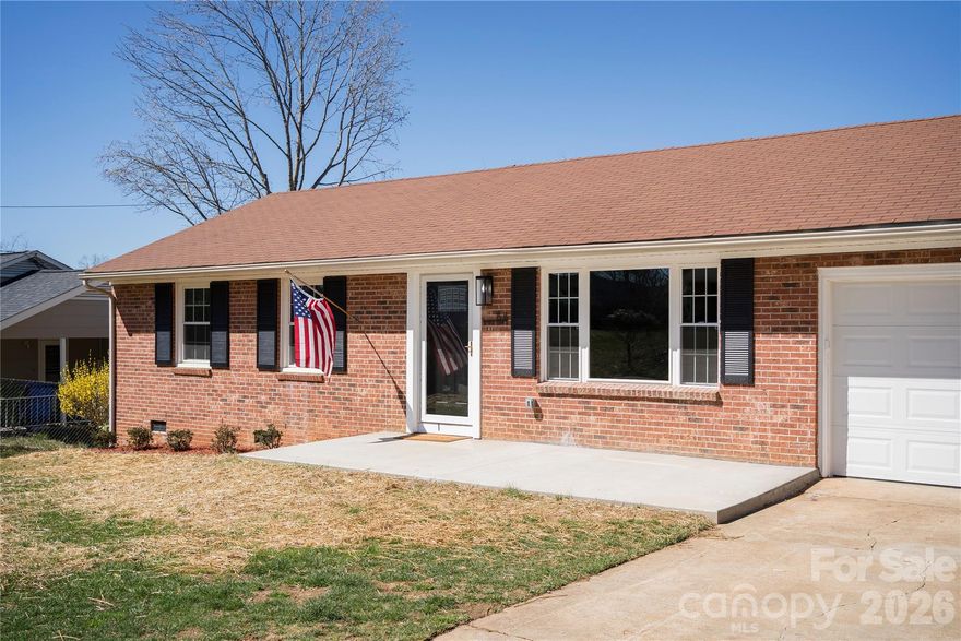Beautifully renovated brick rancher in a quiet pocket neighborhood of West Asheville, with a flat yard, one-car garage and expanded driveway, basement, and two full bathrooms - a combination that's genuinely rare in Asheville. Inside, a gas fireplace anchors the living room, and the kitchen is all new: granite countertops with a breakfast bar and farm sink, modern cabinetry, all new appliances including gas range, convection microwave, and discreet dishwasher, all over restored hardwood floors. The new laundry room off of the kitchen provides plenty of space and storage and flows into the one-car garage. A large lower-level flex space adds serious square footage for a family room, home office, gym, or all three. Outside, the fenced level yard has room to breathe, the basement handles storage or doubles as a workshop, and expanded driveway parking means guests have somewhere to park off the street. Other updates includ: new lighting, updated electrical, new windows in the Carolina room, tiled floors in the laundry and bathrooms, a new tiled shower, and PEX/PVC plumbing. Tucked off of Patton Ave, you're minutes from Haywood Road, downtown, and Mission Hospital - on streets quiet enough you'd never know it. Don't miss this one! Book your showing today.