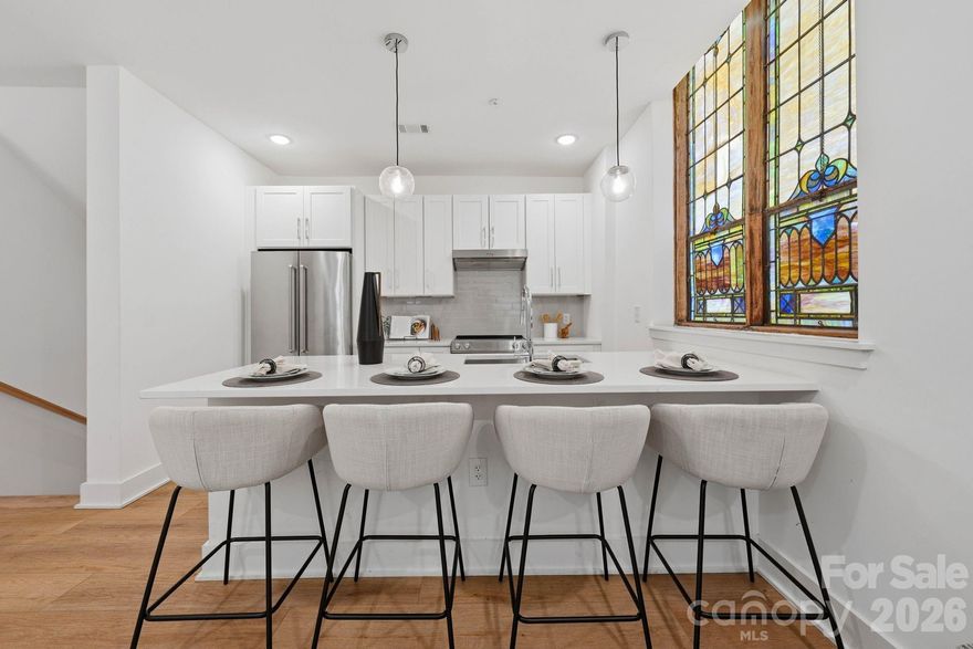 A truly rare opportunity to own one of the most architecturally distinctive residences within The Arches—a boutique collection set inside a meticulously restored 1927 church in the heart of Wesley Heights. Unit 13 showcases some of the most coveted original elements of the building, including stained-glass windows and a dramatic wood vaulted ceiling, seamlessly blending historic character with refined, modern living. Originally constructed as a place of gathering and community, the building has been thoughtfully transformed while preserving its historic integrity and timeless presence. This residence offers a private entrance, creating a sense of individuality and privacy that is rarely found in condominium living. Inside, the main living space is both striking and inviting, defined by soaring ceilings, architectural detail, and abundant natural light filtering through the original stained glass. The open-concept layout flows effortlessly into a beautifully designed kitchen featuring quartz countertops, stainless steel appliances, subway tile backsplash, pendant lighting, and modern cabinetry, offering both functionality and elevated design. Spa-inspired bathrooms include porcelain tile shower walls and floors, complemented by clean, contemporary finishes throughout. The thoughtful layout balances historic charm with modern convenience, creating a unique and highly livable space. Designed for a low-maintenance, lock-and-leave lifestyle, this residence is ideally positioned just minutes from Uptown Charlotte, with easy access to South End, I-77, greenways, and some of the city’s best restaurants, breweries, coffee shops, and entertainment. Walk, bike, or take advantage of nearby transit options to fully experience the vibrancy of Wesley Heights and the surrounding areas. This is more than a home—it’s a one-of-a-kind living experience that captures the essence of Charlotte’s history while delivering the style, comfort, and convenience of modern urban living.