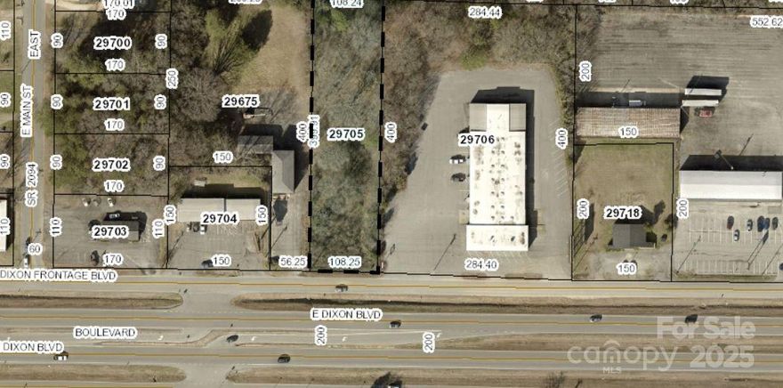 Commercial lot on Dixon Boulevard.  Most of lot is zoned general business; a small part at rear is residential currently. Public sewer will require a pump up to and down the ROW of the Service Rd that serves the property along Dixon Boulevard.  Possibilities include small retail, offices, multi-family.
Lot has trees currently, and has office building on W side and former bakery on E Side.
Traffic count is between 30,000 and 40,000 per day on Dixon Boulevard.