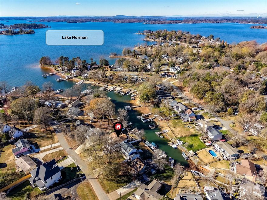 Welcome to your peaceful waterfront retreat with a minimal HOA, tucked away in a quiet cove in the heart of Cornelius, just minutes from the Cain Center for the Arts, shopping, dining, breweries, and parks. A rare and valuable feature, the private pier and dock accommodate two boats, offering easy access to Lake Norman’s main channel and elevating this property into a true lakefront escape. Inside, the bright and airy open floor plan offers a natural flow ideal for everyday living and entertaining. The upgraded kitchen features quartz countertops, a large island with storage, abundant cabinetry, stainless steel appliances including refrigerator, double ovens, five-burner gas cooktop, tile backsplash, and upgraded lighting. The light-filled great room includes a ceiling fan and seamless access to the deck, creating effortless indoor-outdoor living with peaceful lake views. The primary suite provides a private retreat with recessed lighting, ceiling fan, private deck access, walk-in closet, and en-suite bath with dual vanity, tiled shower, and soaking garden tub. Additional highlights include exceptional storage throughout, including a storage shed. Outdoor living is enhanced by an expansive covered deck with step-down access to a large paver patio with fire pit, while the private dock offers open views toward the main channel — perfect for enjoying the Lake Norman lifestyle.