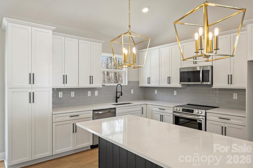 Recently completed and now available, welcome to North Pines—Lincolnton’s newest collection of thoughtfully crafted single-level homes by Brancer Homes. 2271 Lee Lawing Road blends elevated finishes, modern farmhouse charm, and the natural privacy of tree-lined homesites—all just 15 minutes from downtown Lincolnton and convenient to everyday shopping in Sherrills Ford and Denver.

The inviting exterior showcases classic brick accents and stained wood front-porch columns, delivering warm curb appeal with a clean farmhouse aesthetic. Inside, the builder’s Modern Farmhouse Designer Package combines crisp cabinetry finishes, curated lighting selections, stylish hardware, and quartz countertops throughout for a fresh yet timeless feel.

The open-concept kitchen features a spacious island with pendant lighting and flows seamlessly into the vaulted main living area, creating an airy, light-filled space ideal for both entertaining and daily living. The primary suite highlights a beautifully tiled shower wall and designer finishes that balance comfort with farmhouse-inspired character.

Additional features include added recessed lighting, a functional drop zone, and a well-appointed laundry room with upper cabinetry and quartz counters for enhanced storage and convenience. An extended two-car garage with exterior exit door, along with additional driveway parking, adds to the home’s everyday functionality.

Now that construction is complete, this home is part of a newly released collection in North Pines—offering a rare opportunity to own move-in ready new construction with elevated design and modern farmhouse appeal in one of Lincolnton’s fastest-growing areas.Additional features include added recessed lighting, a drop zone, and a laundry room with upper cabinets and quartz counter for extra storage and functionality. The home also includes an extended two-car garage with exterior exit door and additional driveway parking, making this layout as practical as it is stylish.

Set in a low-maintenance community with peaceful rural surroundings, this home pairs craftsmanship, modern design, and timeless farmhouse appeal—perfectly suited for life in Lincolnton.