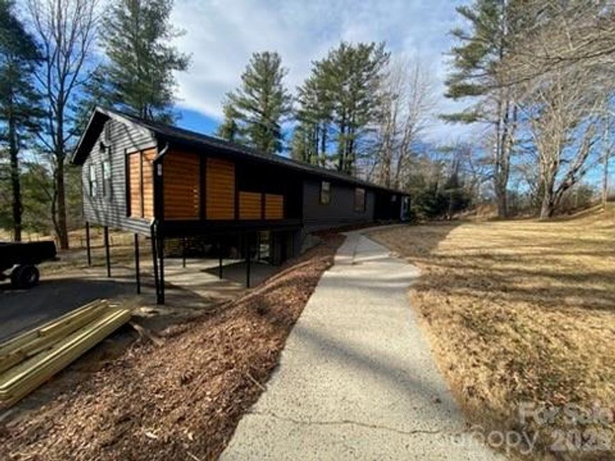 Handyman special with great bones, loads of potential, and an excellent location just outside the walkable Olivette Farm area. Set on a beautiful, level, sun-filled lot just under half an acre, the property is dotted with mature hardwood trees and offers a peaceful, pastoral setting on a very quiet street surrounded by higher-value homes but with no HOA fees.

This site-built home offers comfortable one-level living with a versatile floor plan and has received a recent light refresh, including shiplap paneling throughout. The spacious owner bedroom features a covered porch, creating a quiet retreat with views of the surrounding landscape. Tax records reflect approximately 1,677 sq ft; however this includes a 95+/- sq ft portion of an additional room suitable for an office or third bedroom in which the ceiling height is 2" lower than 7 feet (suitable for a closet) and is not included in the square footage for the MLS listing.  Buyer's agent to confirm square footage.

A full unfinished basement of approximately 1,128 sqft provides outstanding workshop or storage, or future expansion potential. 

Olivette Farm is just a short walk away, offering a rare opportunity to enjoy proximity to one of the area’s most beloved destinations without the Olivette price point. An adjacent parcel is also available, adding flexibility for future improvement or investment. Conveniently located less than 10 minutes from Ingles and the shops and services along New Leicester Highway.

There is no septic permit is on file. A new water line with fire hydrant is located in front of the property, and connection to city water may be available at buyer’s discretion.

This property is being sold AS-IS, WHERE-IS. While updates are needed, the combination of lot, layout, location, and long-term upside makes this an ideal opportunity for buyers looking to build equity, investors seeking a value-add project, or anyone with vision drawn to a special setting.