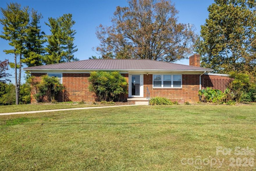 Enjoy sweeping mountain views right from your front porch or living room window—an ideal backdrop for peaceful living. Inside, you'll find a very nice layout with a cozy living room, plenty of natural light throughout and spacious bedrooms. This home offers beautiful hardwood flooring in the living room, hall and bedrooms. The large living room has a cozy fireplace and a huge window to enjoy those beautiful mountain views and lots of natural light. The kitchen and dining area are open and perfect for entertaining. 3 bedrooms on the main level are spacious with ample closet space in each room. The basement features a laundry area and functioning bathroom and still has lots of space for possible additional rooms, workshop or storage. The all-brick exterior and metal roof not only adds classic charm but also provides long-lasting, low-maintenance durability. Other exterior features are a private covered patio and nice large flat backyard that would be great for barbeques.