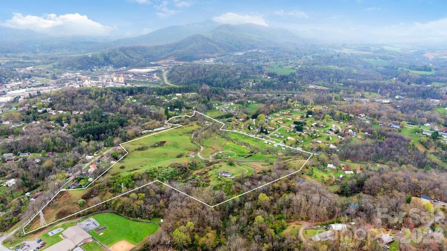 This expansive 42-acre property, spread across five parcels, features gently rolling, fully fenced pastures ideal for agriculture or future residential development. With wide-open fields, mountain vista views from select points, and optimal topography, the land is perfectly suited for a subdivision layout, including stormwater infrastructure. A sewer line runs along the lower edge of the property, adjacent to the creek, enhancing development potential. The property includes an existing doublewide and a former retirement home structure that may be revived for future use [Buyer to verify]. Conveniently located just 5 minutes from Canton’s Main Street, this unrestricted property offers versatility, value, and scenic beauty—all within minutes of town.