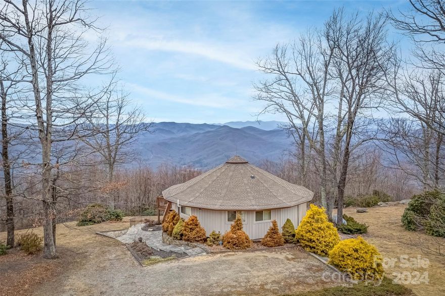 Nestled atop a mountain, this residence offers stunning long-range, year-round mountain views, providing a tranquil retreat from the bustling world below. The open floor plan seamlessly integrates the living, dining, and kitchen areas and invites the outside in through the bank of windows.  The living room, with its cozy fireplace, becomes a focal point for family and friends to come together. Enjoy the views and fresh mountain air while dining and entertaining on the deck. With two main-level bedrooms and baths and a private primary suite on the walk-out basement level, guests and family members alike will enjoy privacy and comfort. The primary en-suite features a seating room with a fireplace and access to the patio. The detached garage provides a place for all of the outdoor gear and toys to be stored or for a small camper to be stored. Offered as a turnkey property, this mountain-top home is ready for you to move in and begin your best mountain life.