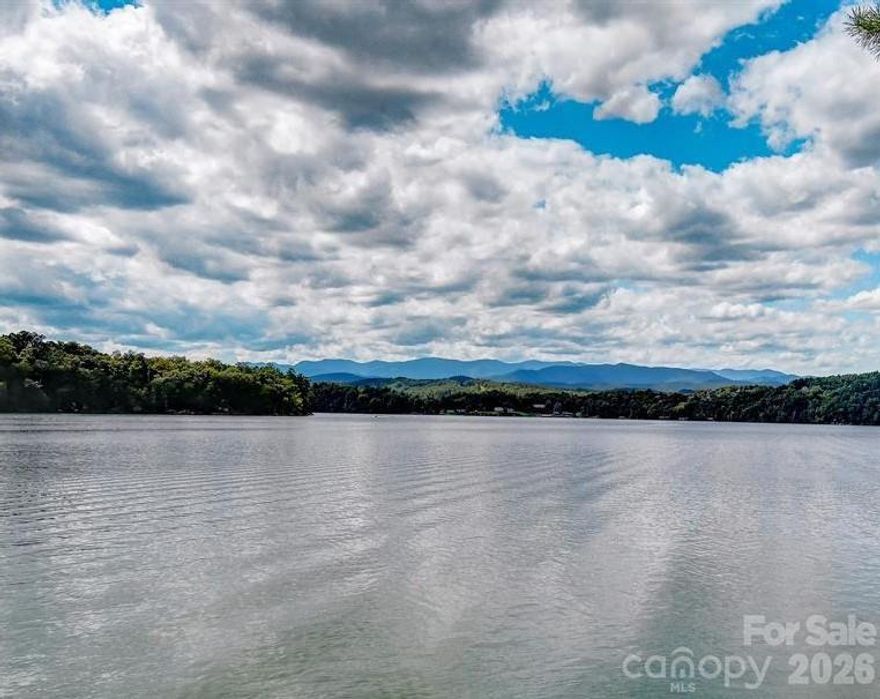 Nestled within the gated waterfront community of The Peninsula at Lake James, this waterfront parcel offers the perfect opportunity to build your dream lake retreat. Perfect parcel for a multi-level custom home with expansive decks, large windows, or even a walk-out basement.A sloped building site higher up offers sweeping long-range views across the sparkling waters of Lake James to the stunning mountain horizons.Beautifully wooded with generous shoreline and the potential for a private dock (subject to approval), this lot is designed for effortless lake living—whether boating, kayaking, fishing, or simply enjoying the peaceful mountain surroundings. The natural landscape offers privacy while still capturing expansive water and mountain vistas.
Residents of The Peninsula enjoy a tranquil setting with amenities including a waterfront pool, community day dock, and convenient access to outdoor recreation. Just minutes away, explore miles of hiking and biking on the Fonta Flora State Trail, or venture into nearby Lake James State Park for additional trails, beaches, and paddling adventures.
Located a short drive from the charming towns of Morganton and Marion, this property combines the serenity of mountain lake living with easy access to dining, shopping, and local breweries.
Whether you envision a full-time residence or a weekend getaway, this remarkable waterfront homesite offers the rare combination of privacy, recreation, and breathtaking natural beauty in one of Western North Carolina’s most desirable areas.