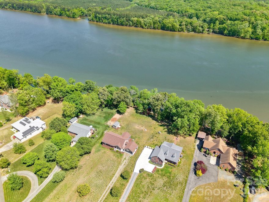 Picturesque, serene, level acre lot with breathtaking lake views! This full brick home is the perfect forever home or family retreat. The open floor plan features a welcoming living room with cozy fireplace and stunning built-ins, flowing into a kitchen with granite countertops and breakfast bar. Freshly painted interiors showcase beautiful hardwood floors through majority of the home. Two bedrooms on the main level with recently remodeled full bath. A true laundry/mudroom on main level. Additional bedroom and full bath upstairs along with a bonus room, and flexible loft space offer room for everyone. Storage abounds at every turn. Two screened porches and a paver patio invite you to soak in stunning waterfront views year-round. A side-load garage adds fantastic curb appeal. Enjoy a naturally preserved shoreline- no dock means unspoiled views and pure tranquility in your backyard. Perfect access for paddle boarding, kayaks or canoe launching. Move-in ready with a brand new roof November 2025, completed pre-inspection, and repairs done. This home offers options for expansion or modifications to fit your needs! Simply arrive and start living your lakefront dream!