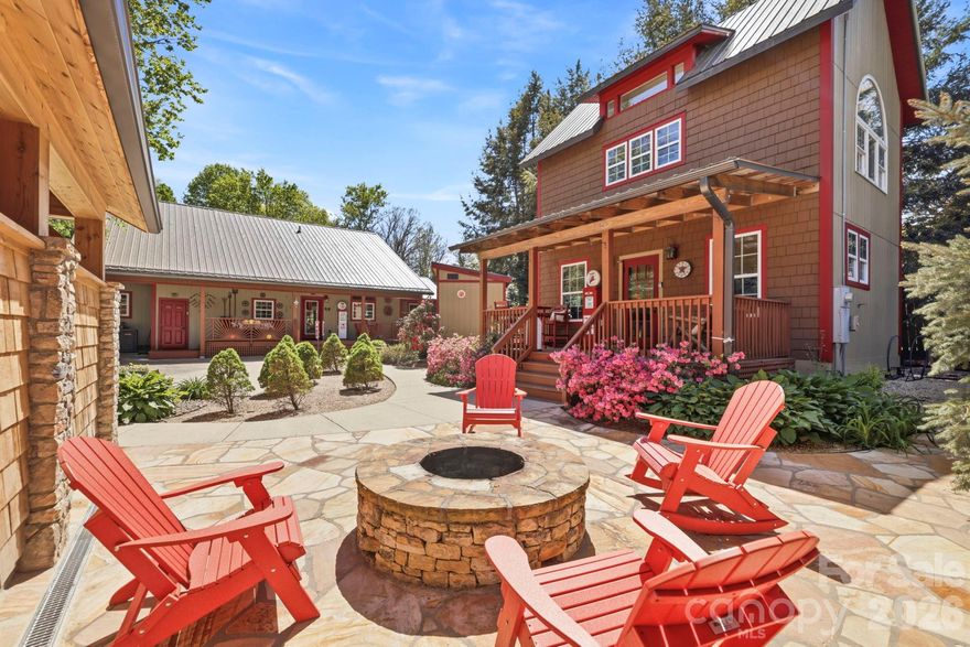 Welcome to 107 5th Street, a rare furnished,  in-town Black Mountain retreat offering a beautifully curated 1500 sq ft main house plus a  628 ft detached guest house with 2 separate studio-style rental units, all tucked away on a quiet dead-end street just moments from downtown. Enjoy easy access to Black Mountain’s beloved dining, shopping, and galleries, with Lake Tomahawk Park, Montreat, Asheville, and area favorites including Biltmore all within easy reach.  

The main house features 2 bedrooms, 2.5 baths, hardwood floors throughout, vaulted tongue-and-groove ceilings, and a custom built-in gas fireplace surround. The open-concept living, dining, and kitchen areas are warm and inviting, with rich wood finishes and a layout designed for gathering. The gourmet kitchen is beautifully appointed with stainless steel appliances, granite countertops, custom wood cabinetry, farmhouse-style sink, large center island with seating, and a thoughtfully designed coffee/beverage station. A window-wrapped vaulted sunroom offers great flex space for reading, games, conversation, or overflow sleeping.

The primary suite feels like a private retreat with 2 walk-in closets, a tucked-away workspace/sitting nook, and a spa-inspired bath featuring dual vanities, soaking tub, oversized walk-in shower, and private water closet. The second bedroom adds charm and personality, while the secondary bath is beautifully finished and guest-friendly. A stylish powder room, attractive hall details, and a spacious laundry room further enhance the home’s comfort and long-stay appeal.

The detached guest house adds tremendous versatility with 2 separate studio units, each thoughtfully designed for privacy and comfort. The upper studio is bright and airy with hardwood floors, a stylish efficiency kitchen, private bath, seating area, and a dramatic arched window that fills the space with natural light. The main-level studio offers a cozy lodge-inspired feel with rich tones, a rustic log bed, efficiency kitchen with seating, and an updated bath with walk-in shower. Both units are beautifully curated and ideal for short-term rental use, private guest accommodations, or multigenerational living.

Outside, the property truly shines. A welcoming front porch, expansive covered rear porch, and guest house porch create multiple places to relax, dine, and gather. At the center of the compound, a stone courtyard with firepit sets the stage for memorable evenings, while the charming covered party pavilion with attached outdoor sauna adds a true resort-style element rarely found this close to town. Framed by attractive fencing, mature landscaping, and beautiful hardscaping, the grounds feel private, polished, and intentionally designed for hospitality.

With separate water and power meters, basement storage, an exterior shed, and a walkable Black Mountain location, 107 5th Street is a rare opportunity to own a distinctive multi-dwelling mountain property with standout hosting appeal.