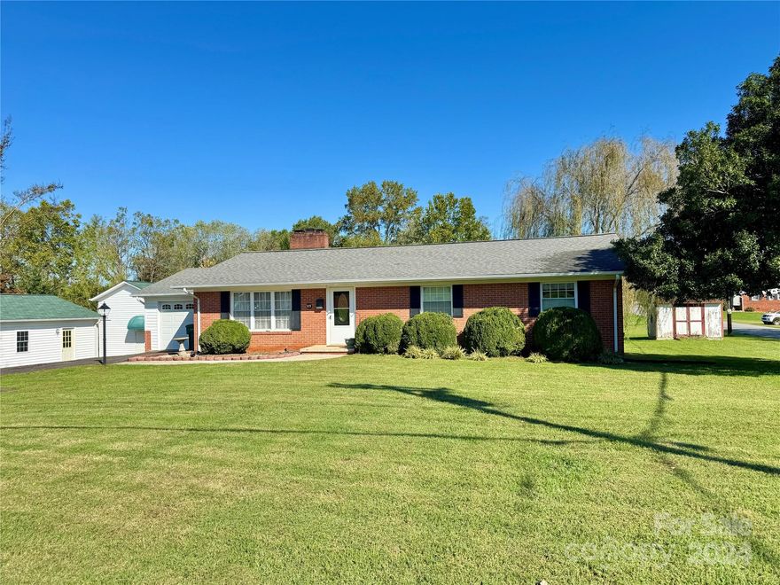 This well-built brick ranch offers a prime location in town, providing convenient access to shopping, schools, and recreational activities.The interior features beautiful hardwood flooring throughout, enhancing the home.The versatile sunroom can serve as a third bedroom, while the kitchen boasts granite countertops and oak hardwood cabinets, creating a warm and inviting atmosphere.Natural light floods the space, complemented by ample storage options, including a walk-in closet.The outdoor area is equally impressive, featuring a gazebo and a level yard, perfect for relaxation or entertaining.Additional amenities include a one-car garage and a full basement, providing extra storage or potential for further development.The primary bedroom features a remodeled tile shower bath.The open-concept kitchen and dining area promote a seamless flow for gatherings.Located near hiking trails, downtown Elkin,and local wineries, this property combines comfort and convenience. No HOA.