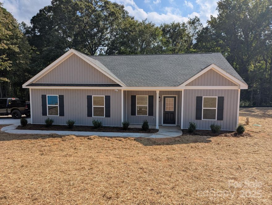 This brand-new construction home boasts stunning curb appeal, featuring front board and batten siding that adds a charming farmhouse touch, along with a covered front entry. Step inside to an open floor plan with beautiful vinyl plank flooring in the main living areas. The kitchen shines with stainless steel appliances, granite countertops and a spacious center island, seamlessly flowing into the dining area adorned with wainscoting and coffered ceilings. The primary bathroom offers a dual vanity, perfect for added convenience and style. Neutral tones throughout the home create a welcoming atmosphere, while the expansive lot, spanning over an acre, provides plenty of room to enjoy outdoor living. Located in a prime Rock Hill area, this home is close to shopping, dining, and other local amenities, all with no added HOA!!