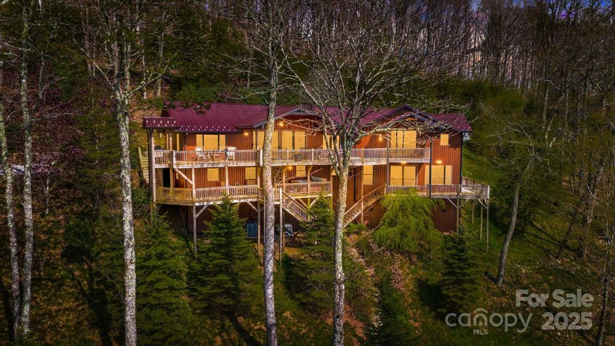 Meticulously maintained, solidly constructed & well insulated 3600 SqFt, 5BD/5BA Mtn retreat seamlessly blends indoor comfort w/outdoor living. Main lvl features a spacious primary suite, 2 add’l BDs, 3 BAs, laundry room & 2-car garage for everyday ease. The LL is designed for both relaxation & entertaining, w/living rm, wet bar, & 2 guest suites, each w/its own ensuite BA, LL laundry room & hot tub w/mtn views. Four zoned central air & heat, whole-house generator & gentle driveway entry w/ample guest parking make this home ideal for seasonal escapes or full-time living.  Price includes Natuzzi leather sofa and all Amish Oak & handcrafted pine furnishings for turn key occupancy. Also includes the surrounding 5 lots to enjoy absolute privacy w/view control. Plan a family compound or develop & sell. Located in the 5,300 acre Wolf Laurel Community w/yr round, long range, mtn views. Watch the twinkling lights from Hatley Pointe Ski Resort w/180 Sunset views. Seller financing available.