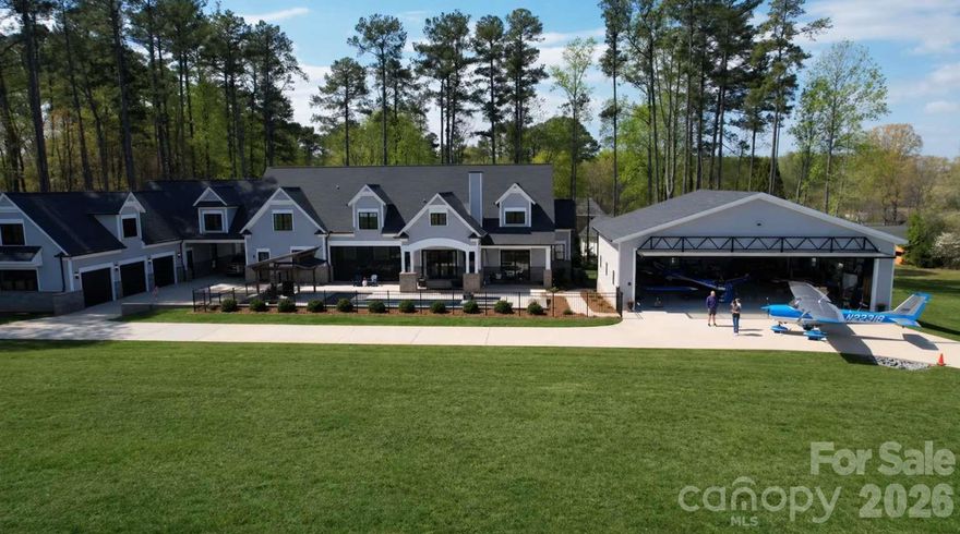 Farmhouse style home built in 2022 at the Lake Norman Airpark blending luxury, comfort, and aviation lifestyle. The open-concept interior centers on a chef’s kitchen with Viking range, 11' island, and 9” hickory floors. The main-level owner’s suite offers his and her bathrooms and separate walk-in closets. While upstairs movie room and office provide flexible living and workspace. Outdoor living includes a 34’x16’ saltwater pool, spa, pavilion grilling area, and 3-car garage with covered drive-through. There is an unfinished apartment with private entrance and a 1,138 sq ft upper level that has been furred out and ready for drywall. This property faces the 3,000’ paved airport runway with direct taxiway access. The 50’x40’ hangar includes a 44’x11’ Higher Power hydraulic door, mezzanine, radiant overhead heat, and attached 36’x24’ epoxy-floored workshop. Airpark amenities include fuel, tie down, hangars, and flight school. Runway repaving set for May 2026.