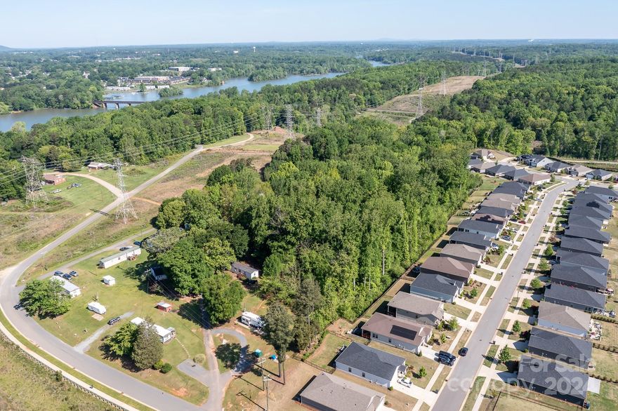 Looking for an income producing property in a sought-after location? Prefer to build? Property is ideally located in Charlotte and is adjacent to The Vineyards at Lake Wylie.  Property is zoned R5, N1-C. Property includes 3 parcels. Parcel ID 113-073-42, 113-073-43 & 113-073-44.  Parcels will NOT be sold separately. Property includes 11 mobile homes (considered personal property and owned by the sellers), 4 rental pads which contain mobile homes that the tenant owns PLUS one single family residence.  Current occupancy is approx 95%. Wells and septic tanks on site.  Current tenants are on a month-to-month lease.  All personal property in Workshop/Storage does not convey.  ALSO LISTED UNDER LOTS/ACRES MLS 4131885.  NO CITY TAXES.  County Taxes only!
  
Close proximity to Charlotte Douglas Airport, I-85, I-485.  Proposed Lynx Silver Line light rail extension with a proposed stop at Sam Wilson Road.
Paved Road Access.  328 feet of road frontage