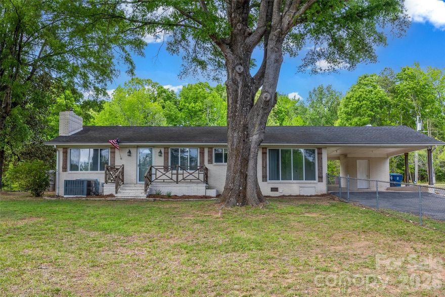 Welcome home to this classic, all-brick ranch in Midland! This home combines timeless durability with the serenity of an acre of land. Featuring 3 bedrooms and 2.5 baths, ensures comfort and convenience for family and guests alike. The open flow between living areas have tons of natural light through the large windows that are all along the front of this home. Original hardwood floors add so much character, brand new quartz counter tops in kitchen, ceramic tiled bathrooms & showers, and an extra large "drop zone" mudroom/laundry room with half bath attached. You will enjoy all the storage and added space this mud room provides- it is a favorite feature of the home! Outside, large mature trees give shade for the fenced in front yard. Out back is a concrete pad for weekend relaxing by a fire pit or grilling out. Or just sit under the carport and enjoy the shade! There is a 2 bay detached workshop with 220 amp outlet for welding. Move-in ready, this property is the perfect retreat for those looking to trade the bustle of the city, yet be close enough to Albemarle Rd and I-485 for easy access and commute.