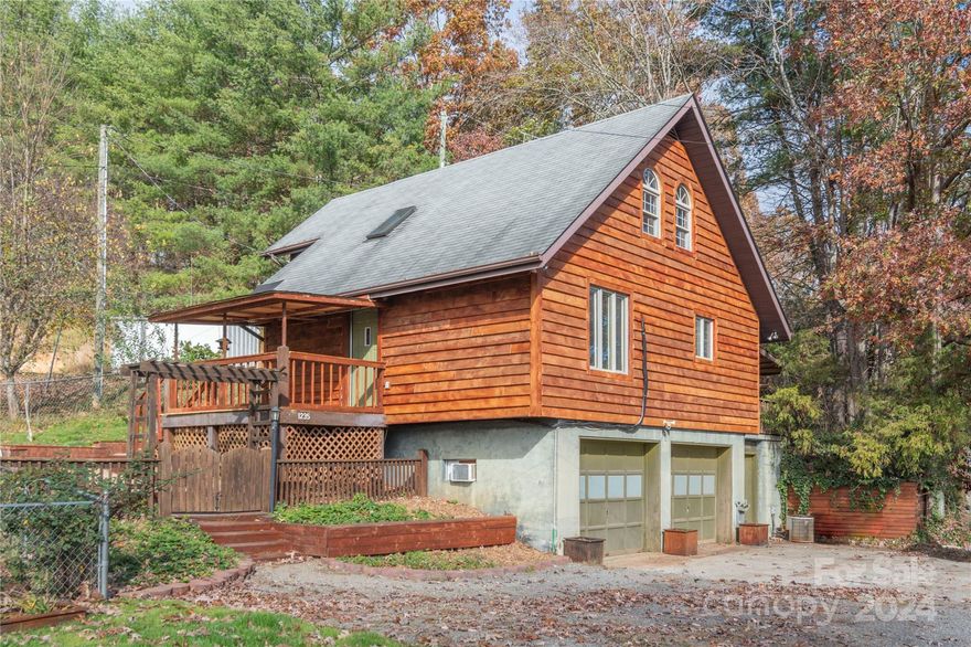 You CAN have a rural setting and all the conveniences of several nearby towns with this charming mountain style home! It's just 20 minutes to Asheville and 10 minutes to downtown Weaverville and Marshall. Wake up to mountain views and be surrounded by perennials and berry bushes on this lovely land, suitable for all your gardening endeavors. This 2 bedroom 2 bathroom home sits on top of a two car garage which also makes for a great workshop or storage space. The yard is fenced in to give you peace of mind if you, your pets or children want to enjoy the outdoors. The current owner converted the 3rd bedroom downstairs into a second living space, but this could easily be changed back into a bedroom if need be. Seller also installed new siding, eco friendly mini split system, and deck. This home is perfectly adorable and functioning with plenty of room for creativity to make it your own!
