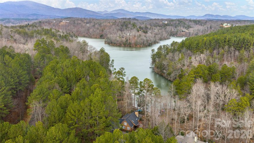LAKE FRONT MOUNTAIN ESCAPE! Nestled in the heart of the picturesque Lake Adger Community this beautiful lake front home offers turnkey convenience for those seeking a vacation getaway or full-time residence. The home is built “lake house style” and features a great room with a vaulted ceiling and open floorplan, a floor to ceiling stone stacked fireplace, a screened porch, a wrap around porch and much more all situated to enjoy year round views of the lake. This property offers rare almost level access at both the house and the waterfront so that you can easily walk down just a few steps between the lake and the house or utilize the 2nd driveway that goes down to the lake so that you can conveniently take your gear down to your own private “lakeside” parking. Outdoor amenities include a large lakeside firepit, spacious hot tub with privacy fencing, a carport with walk-up storage room, a 2nd large RV carport, convenient RV hookups, beautiful stone pathways, a paddleboat, 6 kayaks, deeded access to an adjoining private boat ramp for convenience and your own private floating dock.   If you are looking for a peaceful and comfortable home that is surrounded by nature, then this property is perfect for you. Located in a quiet and peaceful neighborhood that is perfect for those who want to escape the hustle and bustle of city life. Lake Adger has 14 miles of shoreline and 438 surface acres of water where you can enjoy motor boating, kayaking, fishing and swimming. The Lake Adger Community is a private planned community with 3250 +/- acres and includes 13 miles of private equestrian and hiking trails. Life is better at the lake!