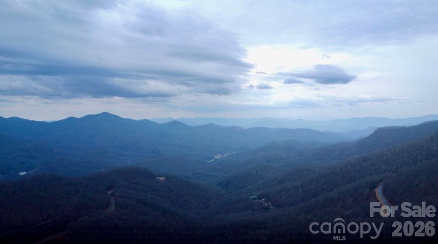 A truly spectacular parcel is now available in Hi-Mtn on top of Balsam. Situated conveniently between Waynesville and Sylva giving one the option of both towns for shopping, dining, recreation and healthcare. Imagine driving to your new home situated at 4590' elevation and literally looking down upon the Blue Ridge Parkway as you make that drive. The Mountains to Sea Trail runs adjacent to the Parkway in this section and affords you to walk out your door and access this trail for daily fitness hikes. Very gentle topography with an exceptionally easy building site. Literally adjacent to and overlooking the iconic Blue Ridge Parkway. Recently expired 4 bedroom septic permit and expired well permit. Recorded survey in 2021. Minimum size home is 1250 sq ft and does come with an $800 per year HOA due in order to maintain the road system and gate. Do not miss out on this exceptional opportunity with this high elevation, west facing building lot overlooking the Blue Ridge Parkway.