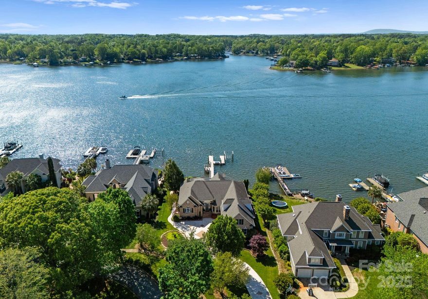 Experience luxury lakefront living at its finest in this meticulously maintained waterfront retreat on prestigious Governors Island. Nestled on a quiet cul-de-sac behind the gates of one of Lake Norman’s most exclusive communities, this 4-bedroom, 3.5-bath residence offers sweeping Lake Norman views & 100 feet of pristine shoreline. Designed to embrace the water from the moment you enter—soaring ceilings, walls of windows, & an open floor plan flood the space w/ natural light, showcasing panoramic lake views. Thoughtful updates throughout, including modern bathrooms, designer lighting, & an updated kitchen, ensure a turn-key luxury experience. Enjoy resort-style outdoor living w/ a saltwater pool, expansive patio, covered terrace, & a private dock complete w/ a boat lift & dual PWC lifts. Located minutes from shopping, dining, & easy access to Uptown Charlotte, this is a rare opportunity to own a move-in-ready waterfront property on one of Lake Norman’s most desirable streets.