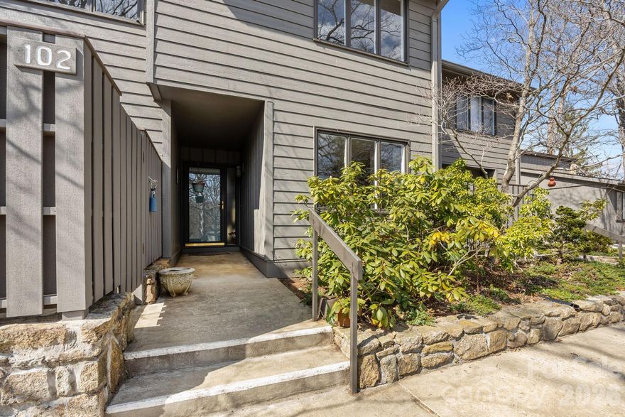 FREE HOA FEES FOR A YEAR!!  Sky-High Ceilings and Modern Sophistication in a Premier 55+ Enclave. Discover a residence where classic comfort meets contemporary flair. This immaculate 3-bedroom, 3-bathroom condominium has been curated for those who appreciate light-filled spaces and absolute peace of mind. From the gleaming oak hardwoods to the soaring architectural lines, every inch of this home radiates quality and meticulous care. The main living area makes a stunning first impression with 17-foot ceilings and a custom sun tube, bathing the space in soft, natural light. Rich oak hardwood floors flow through the dining area and private library, creating a cohesive, modern aesthetic. Enjoy the best of Western North Carolina from your heated glass-enclosed sunroom or step out onto the attached open-air patio for morning coffee among the trees. Three full bathrooms, two of which feature modern walk-in showers, one is on the main level, offer luxury and accessibility for owners and guests alike. The kitchen boasts ample cabinetry, a dedicated pantry, and a brand-new electric cooktop, perfectly situated near the integrated laundry zone. Enjoy total "concierge-level" comfort with a full HVAC replacement (October 2024). The system is under a Gentry Heating maintenance contract with a parts warranty protecting you until 2029. Rare for condo living, this unit features deep closets and a pull-down attic for all your seasonal treasures.